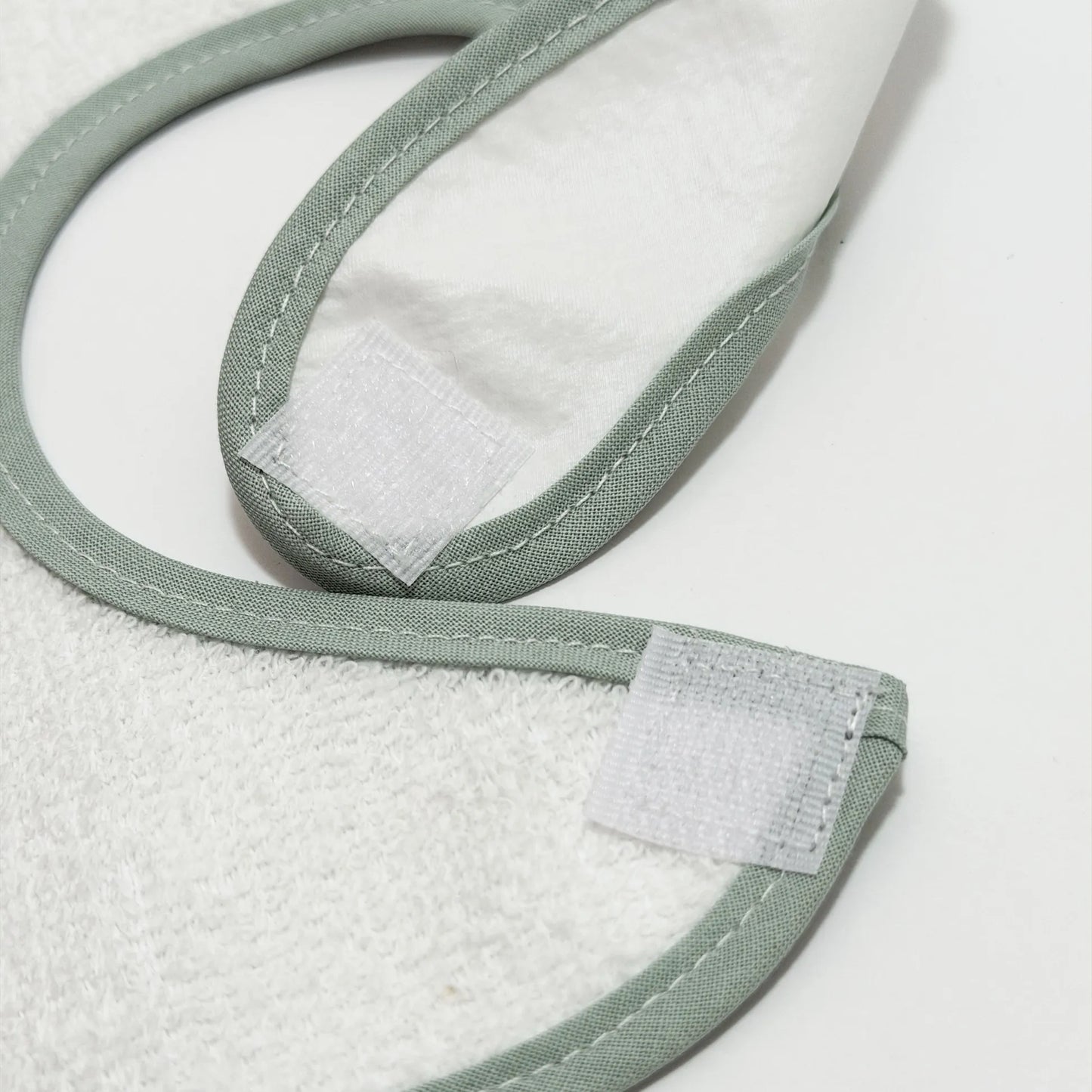 Detalle de babero impermeable con motivo de conejito en la cesta verde