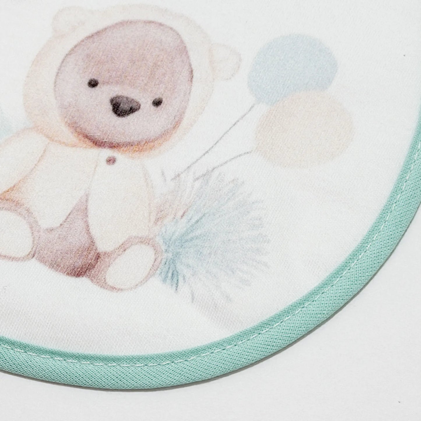 Detalle de babero con motivo de osito con capucha verde