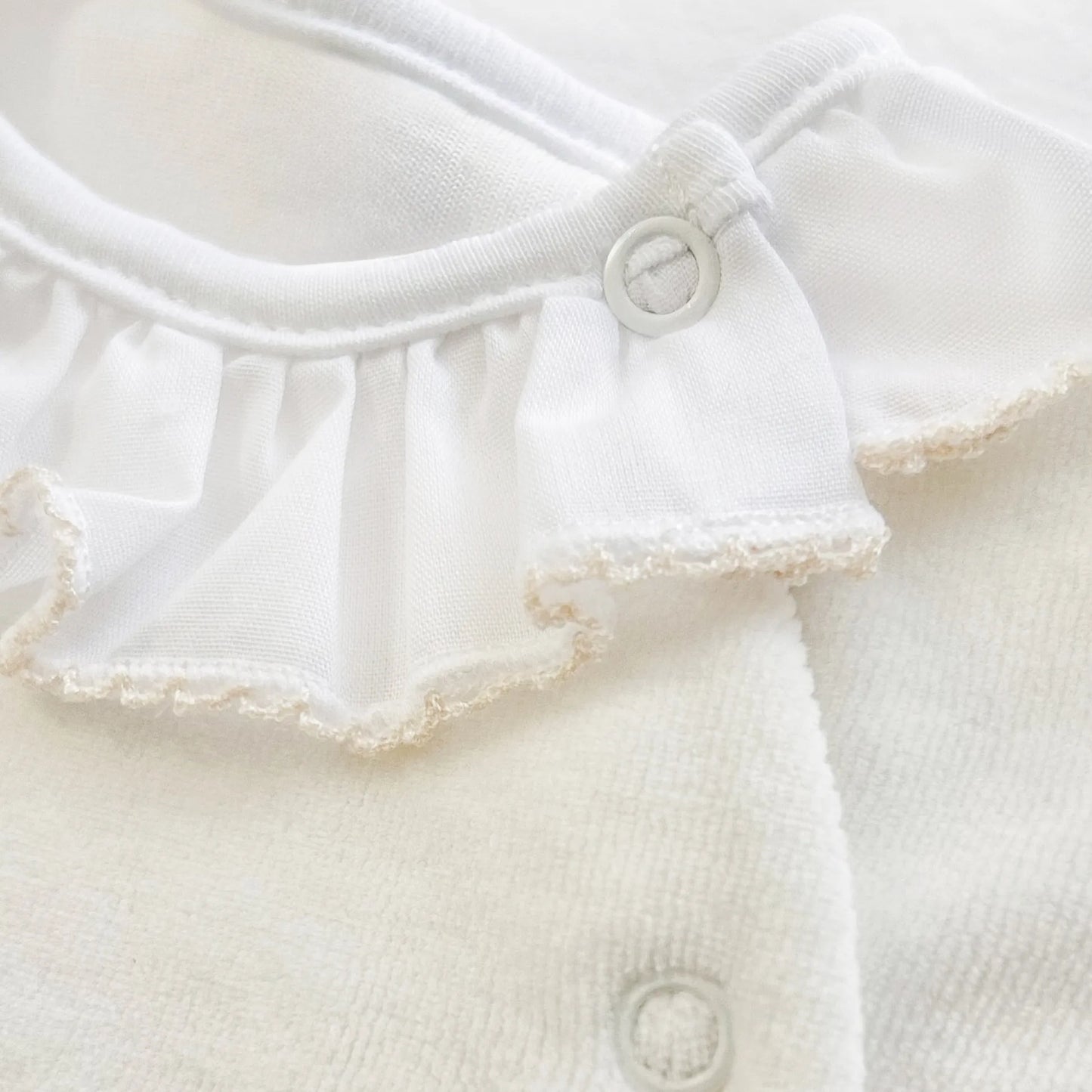 Detalle de pelele con cuello de volante y motivo de osito waffle perla