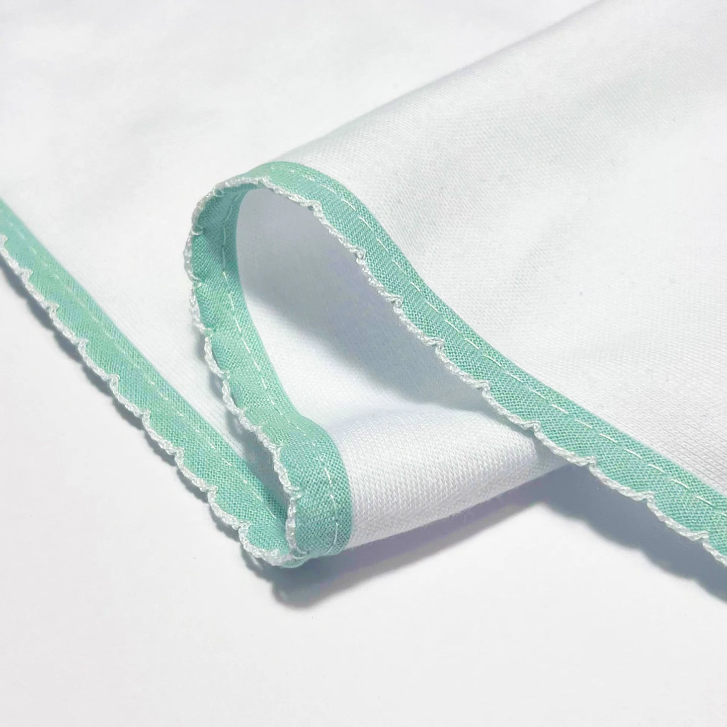 Detalle de paño para eructar con motivo de conejo en relieve verde