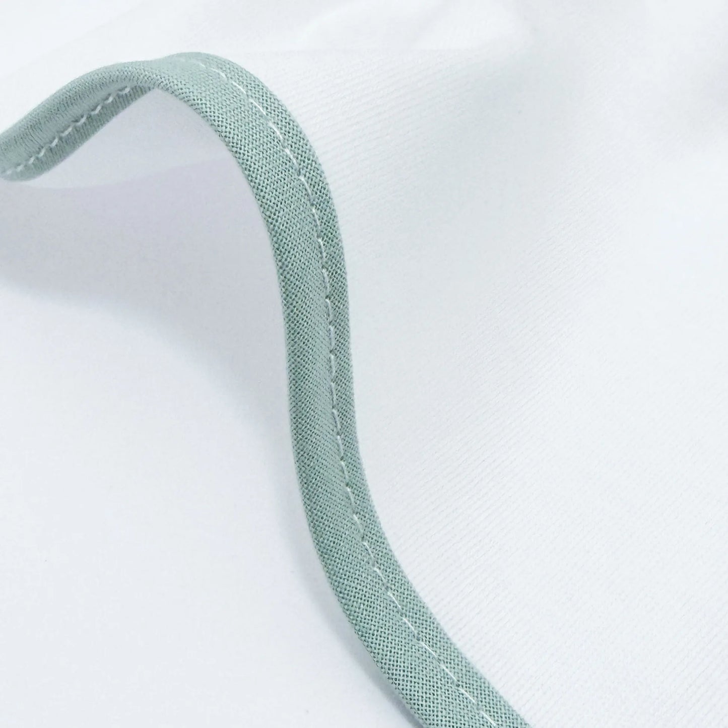 Detalle de paño para eructar con motivo de conejito en la cesta verde