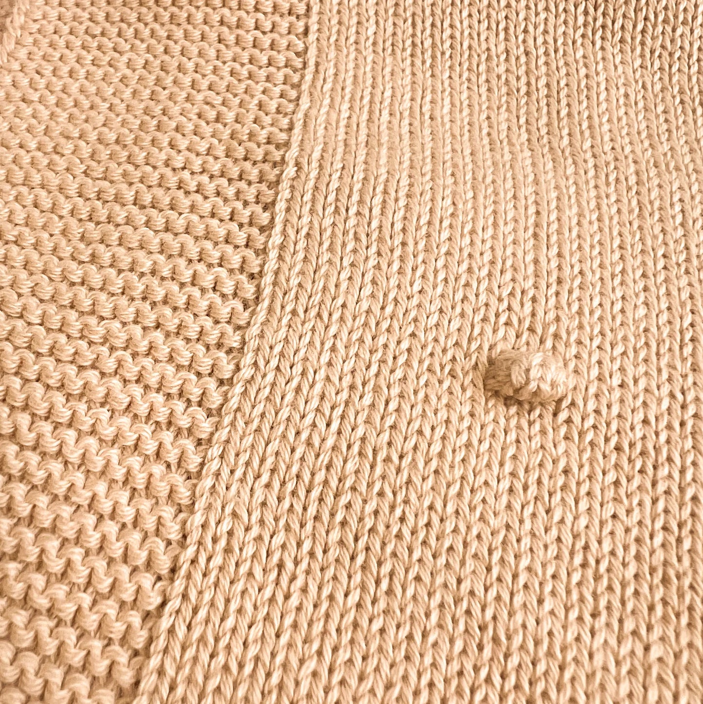 Detalle de manta de punto con relieve de pompones beige