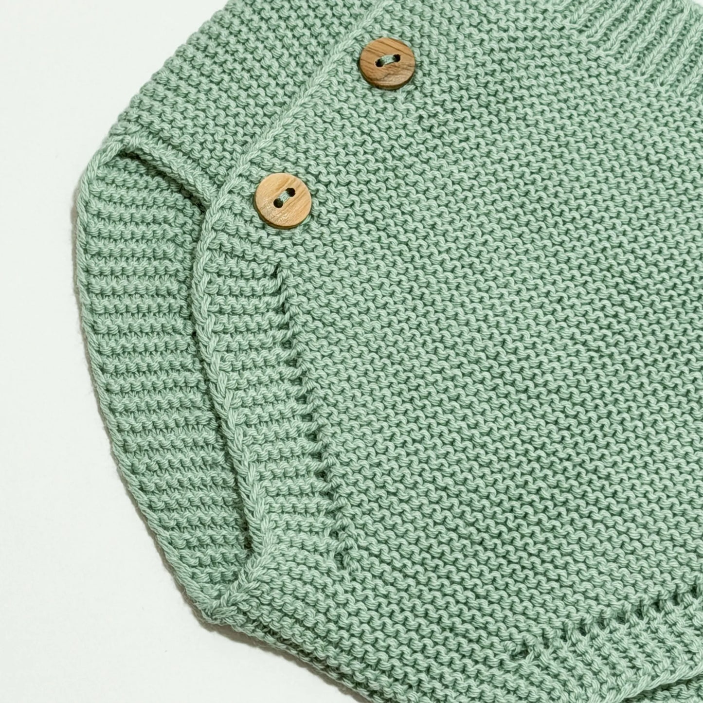 Detalle de cubrepañal de punto con botones de madera verde