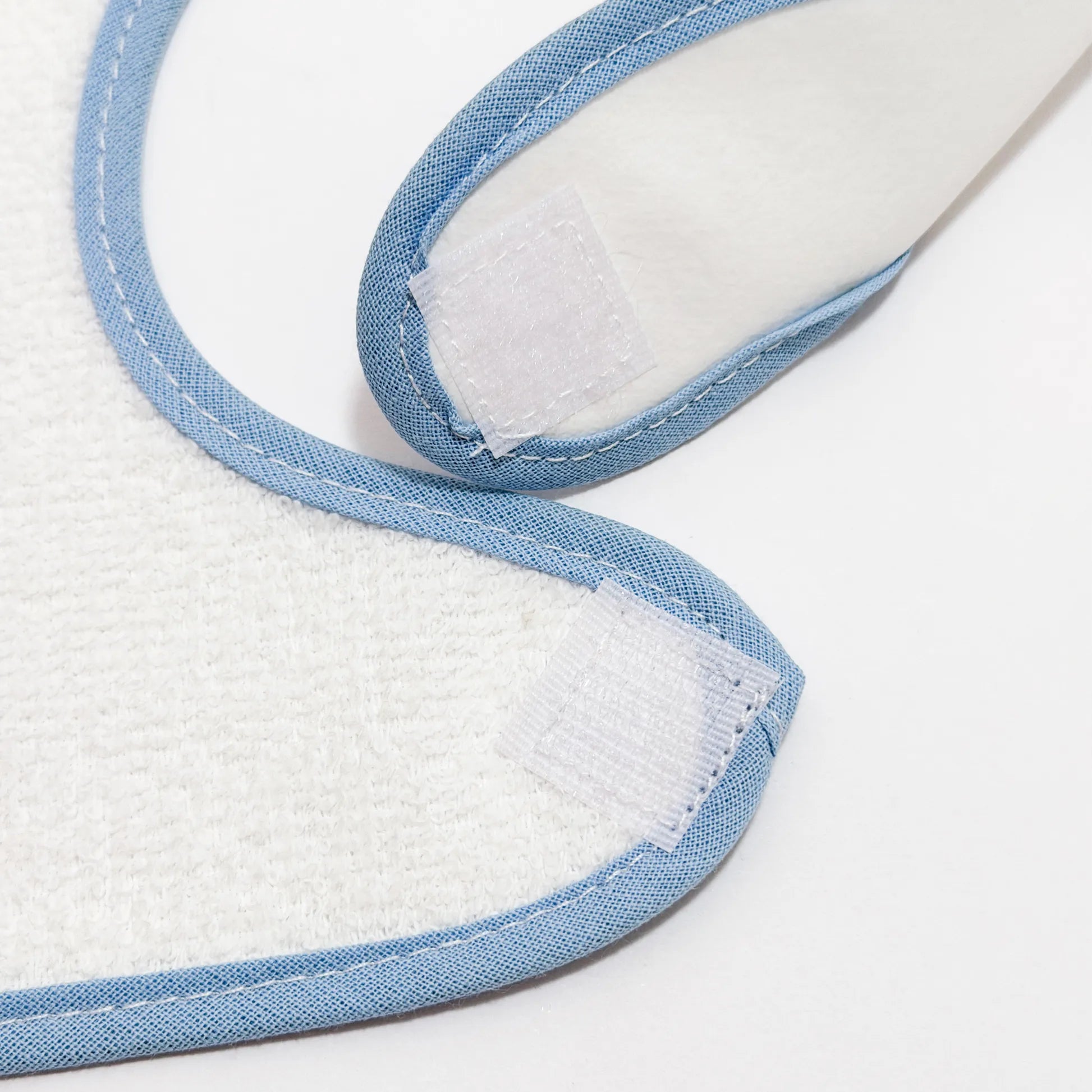 Detalle de babero impermeable con motivo de conejito en la cesta azul