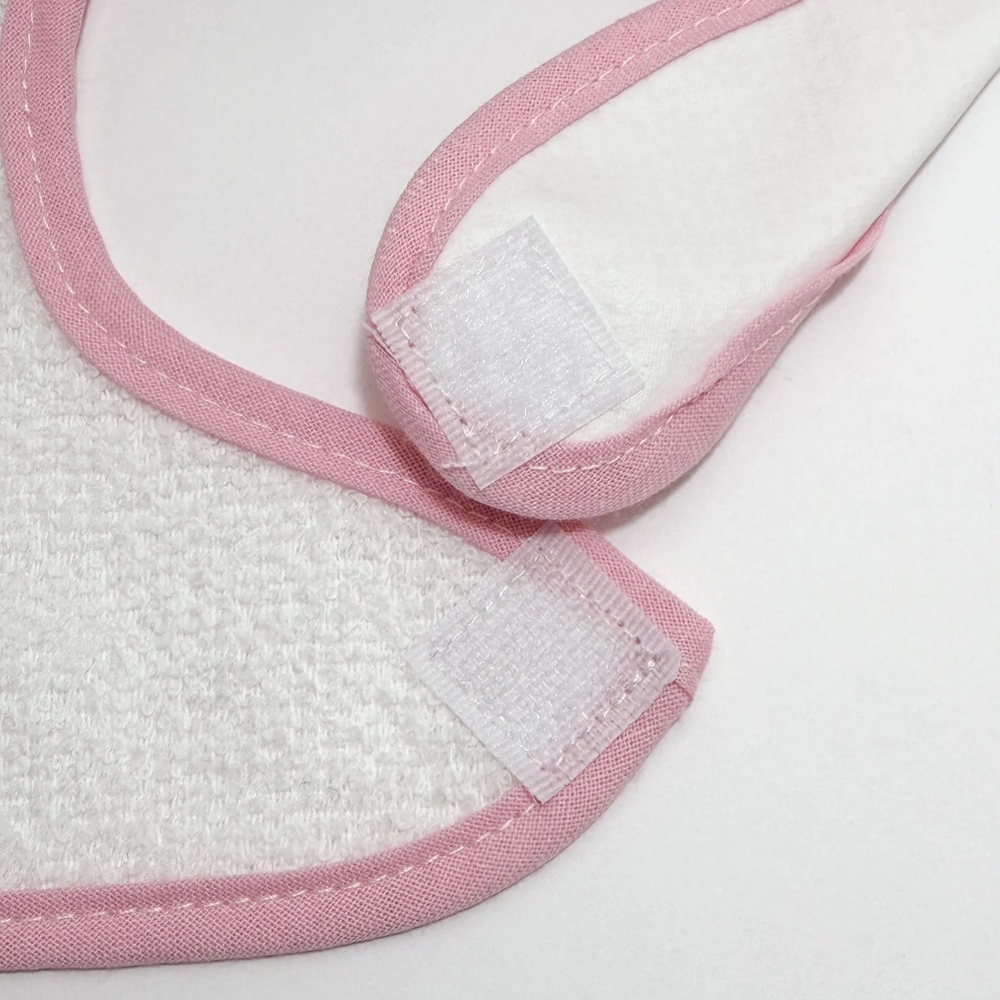 Detalle de babero impermeable con motivo de conejito en la cesta rosa