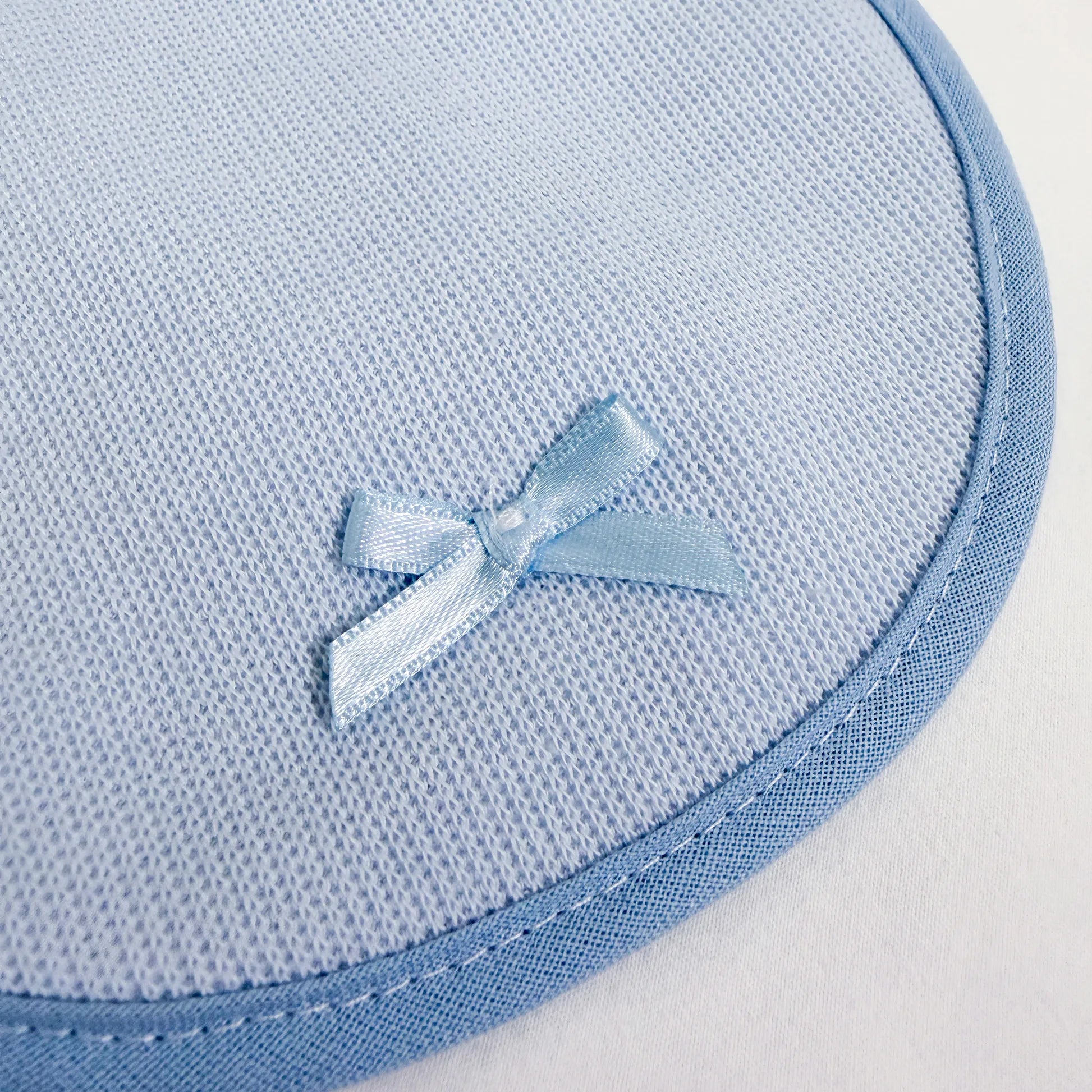 Detalle de babero liso con lacito azul