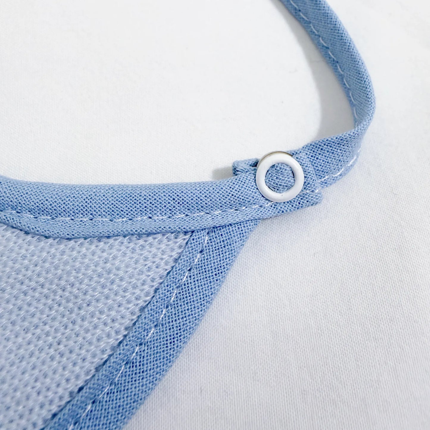 Detalle de babero liso con lacito azul