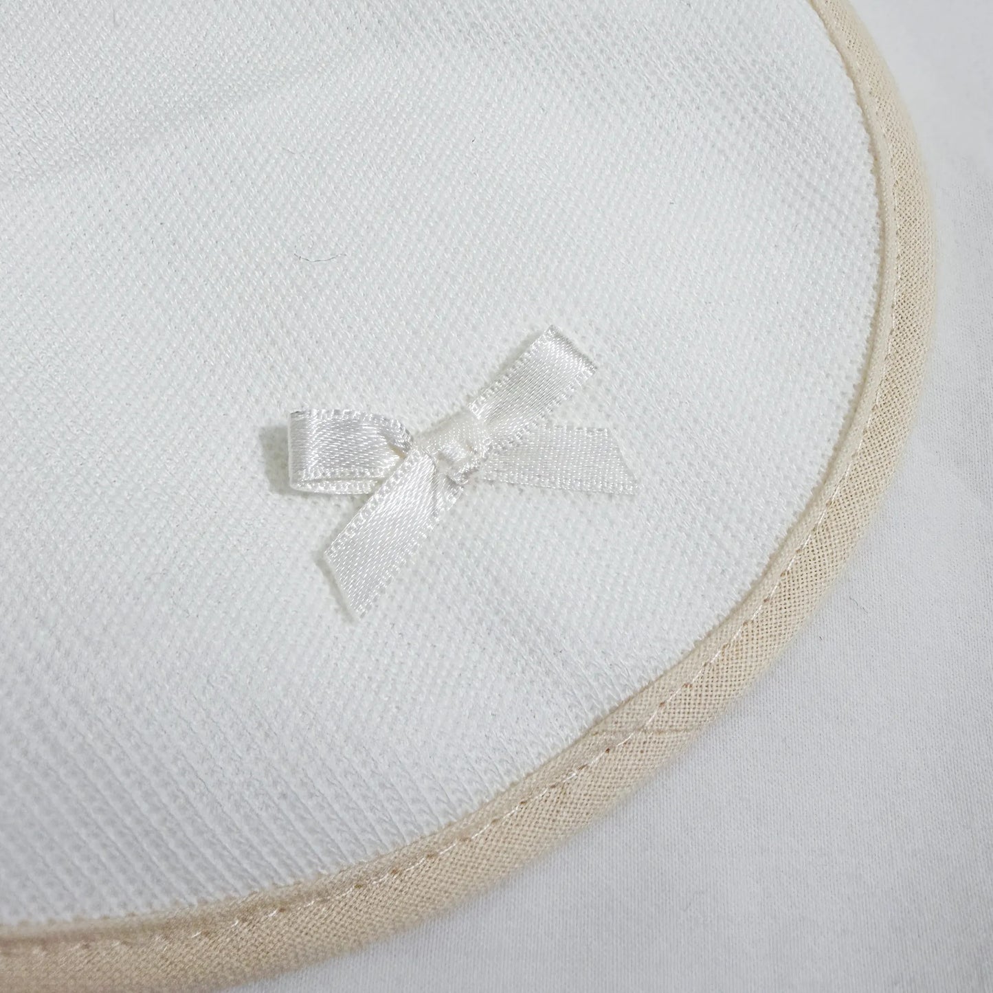 Detalle de babero liso con lacito perla