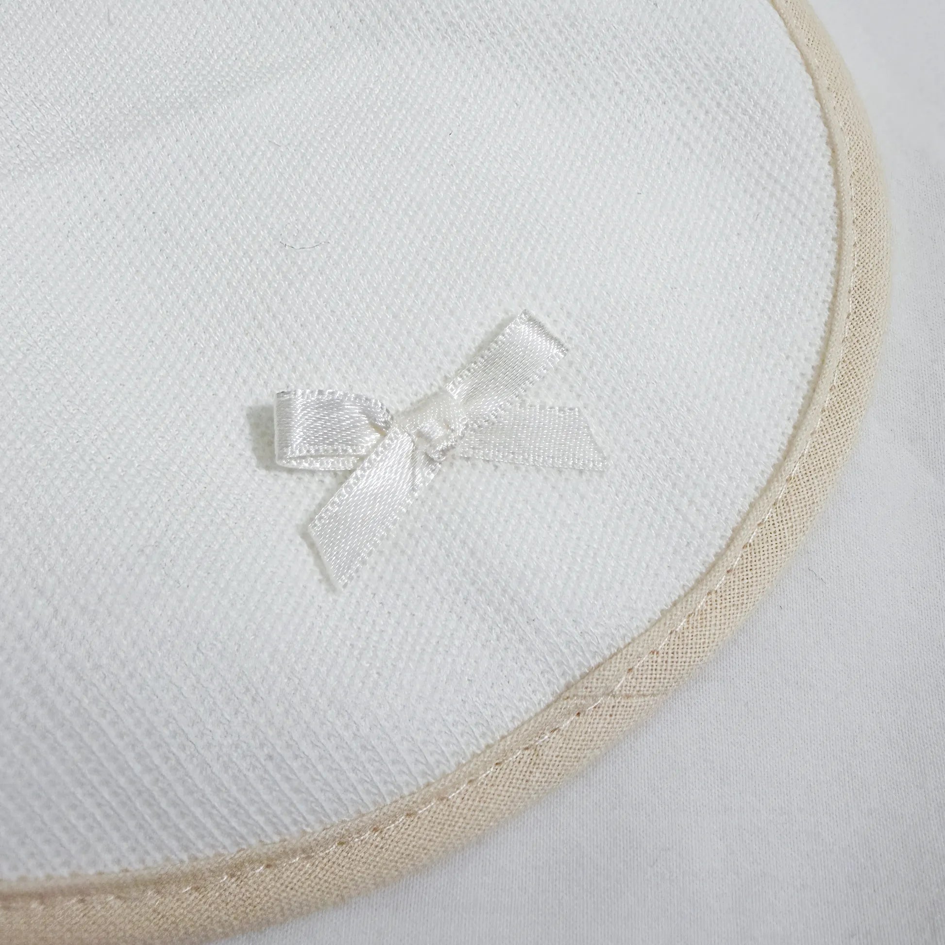 Detalle de babero liso con lacito perla