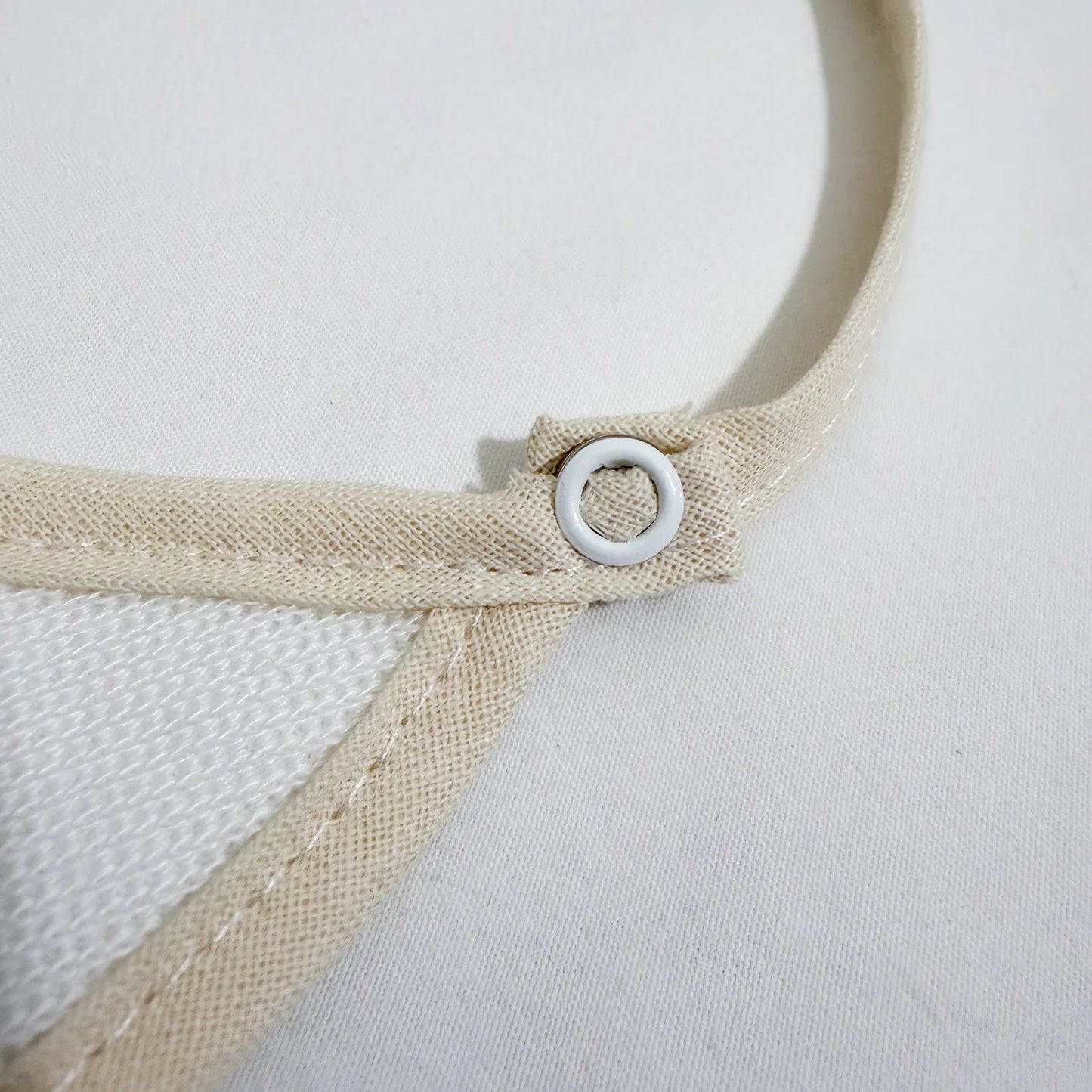 Detalle de babero liso con lacito perla