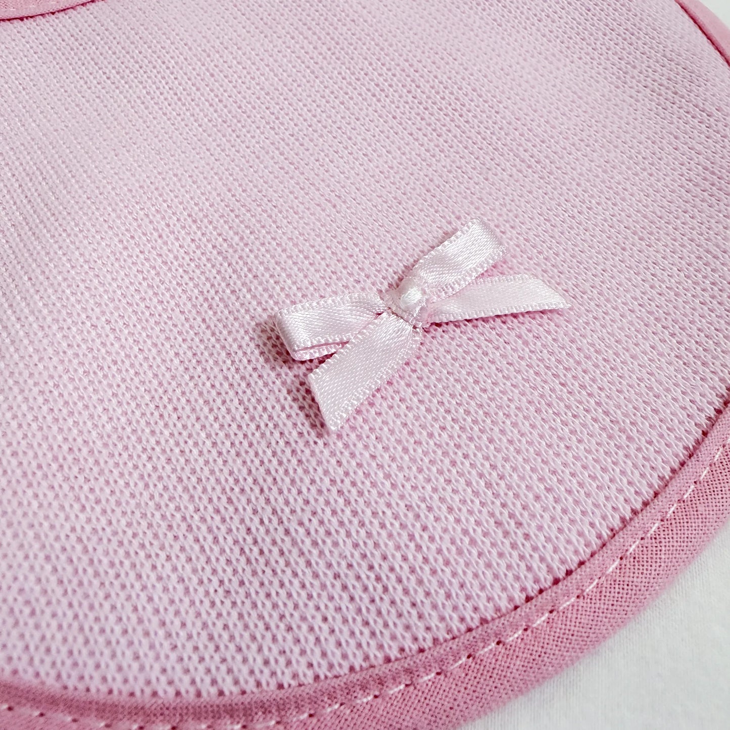 Detalle de babero liso con lacito rosa