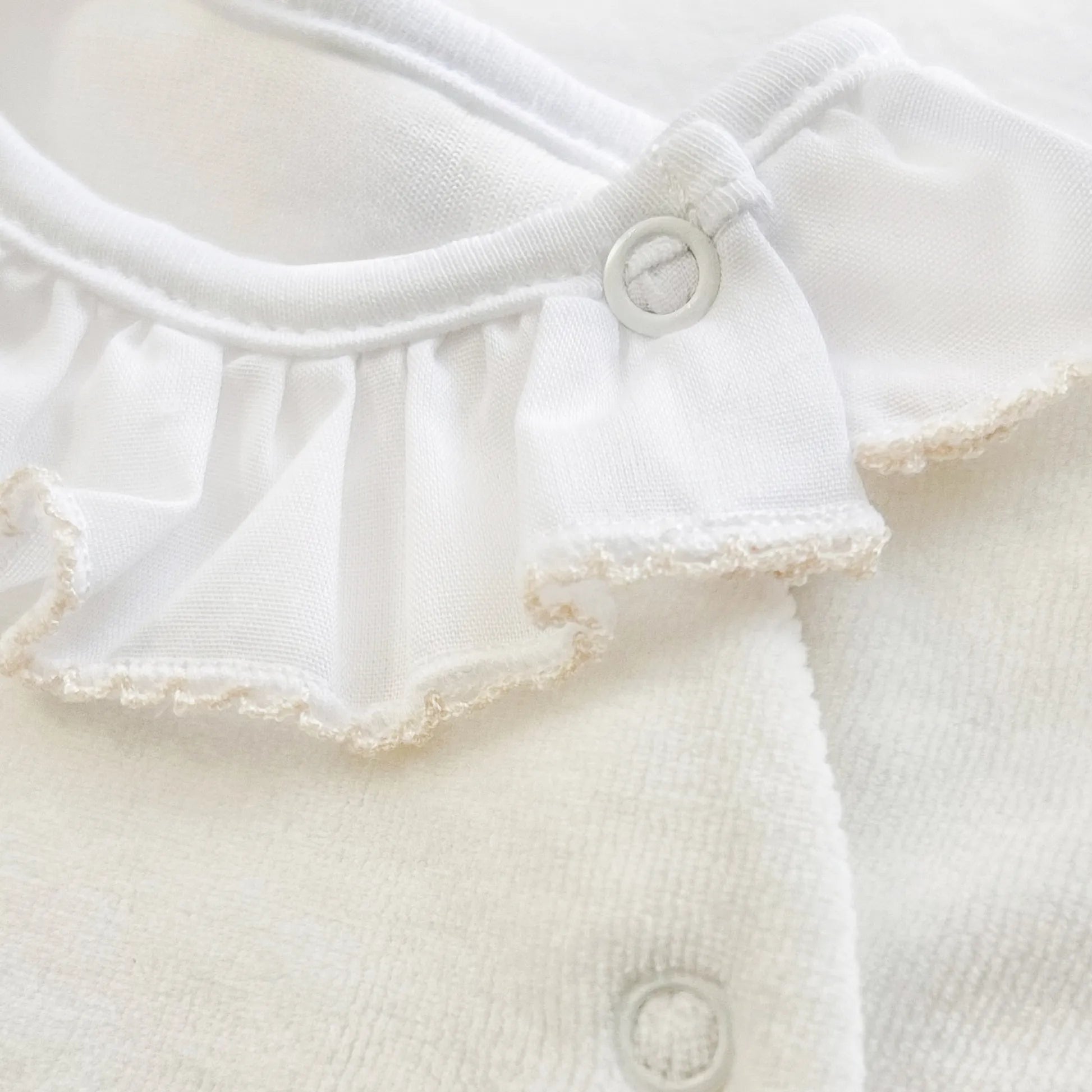 Detalle de pelele con cuello de volante y motivo de osito waffle perla