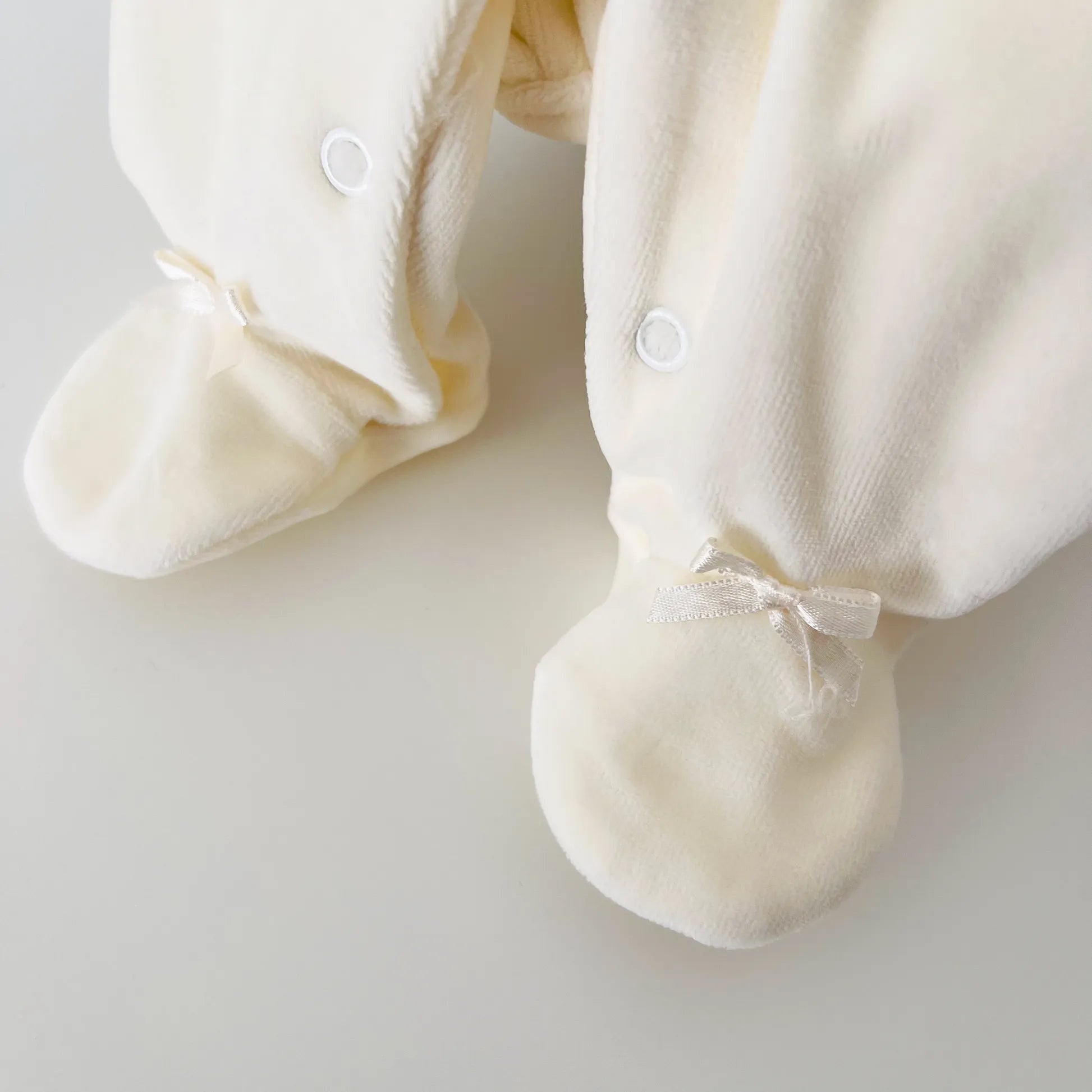 Detalle de pelele de niña con cuello redondo y bordado de rombos perla