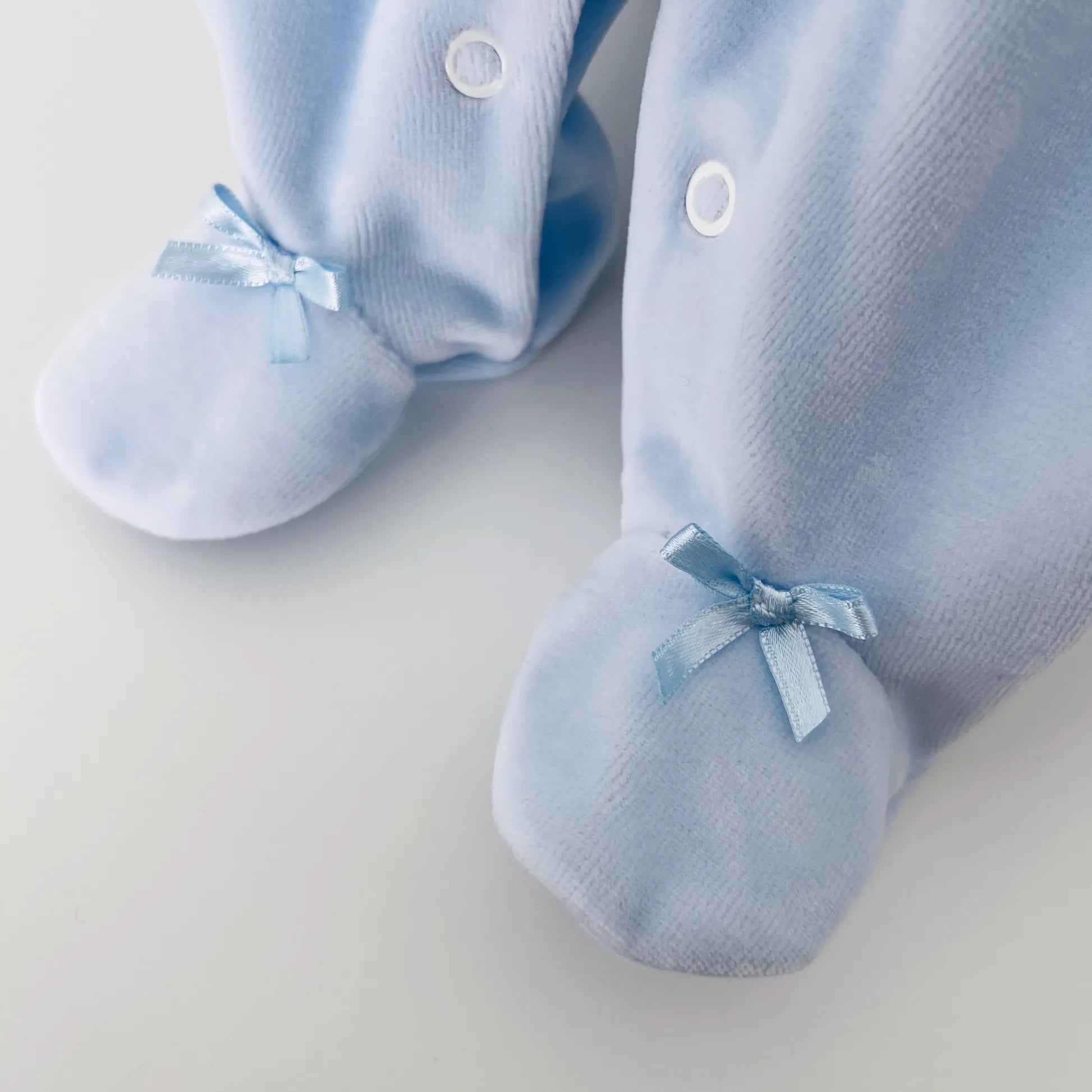 Detalle de pelele de niño con bordado de rombos azul