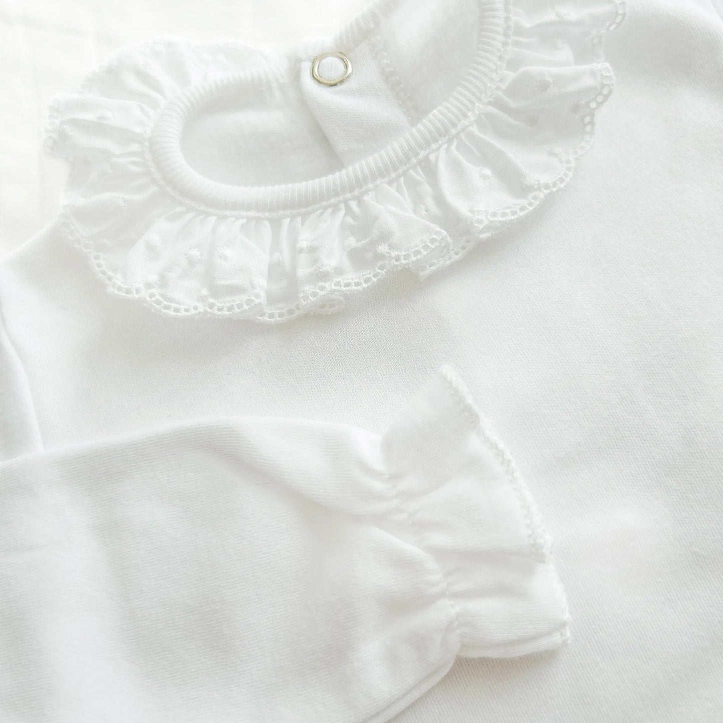 Detalle de body con cuello bordado de lunares perchado blanco