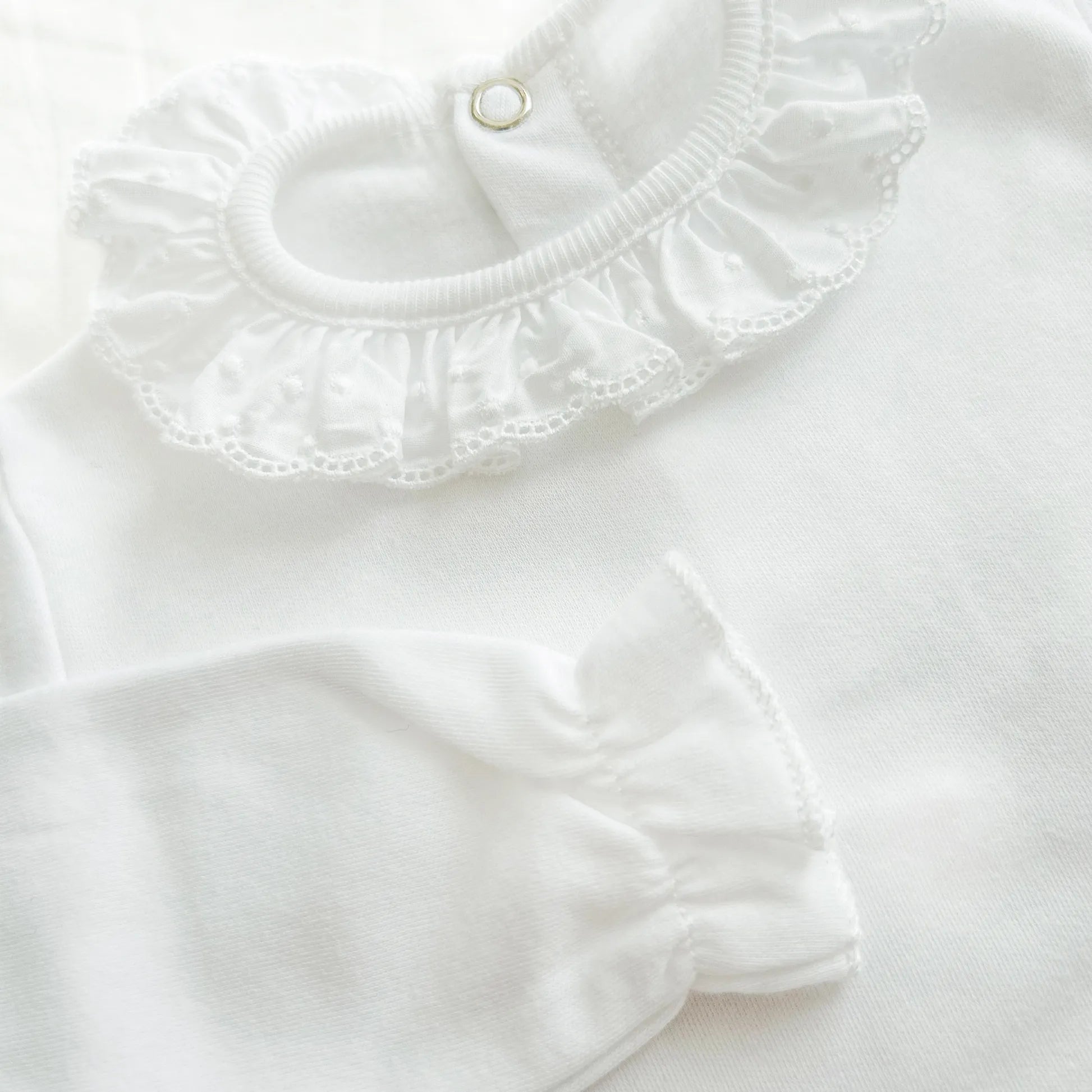 Detalle de body con cuello bordado de lunares perchado blanco