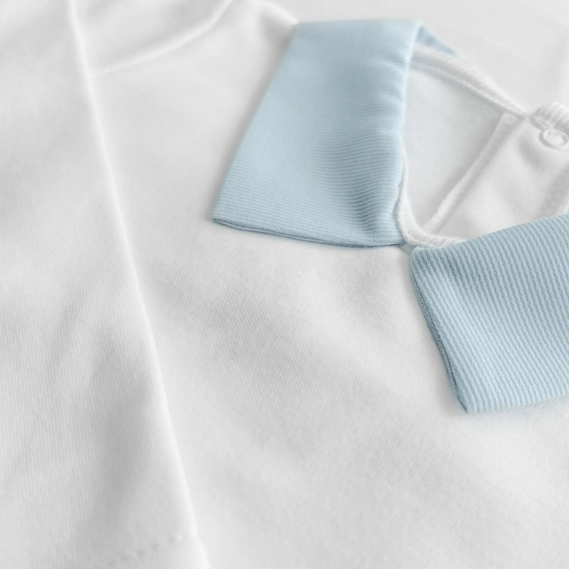 Detalle de body de manga larga perchado con cuello de tela azul en pico