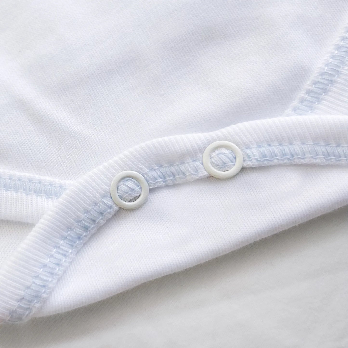 Detalle de body cruzado con leotardo perchado con motivo de conejos de punto y lazito azul