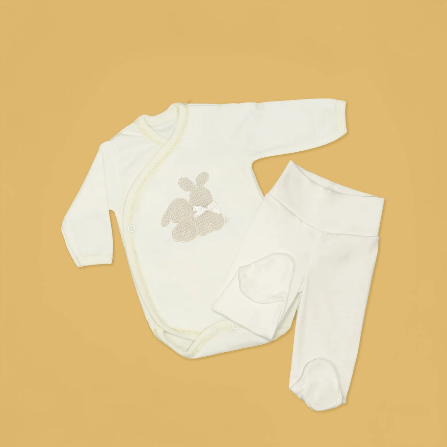 Detalle de body cruzado con leotardo perchado con motivo de conejos de punto y lazito beige