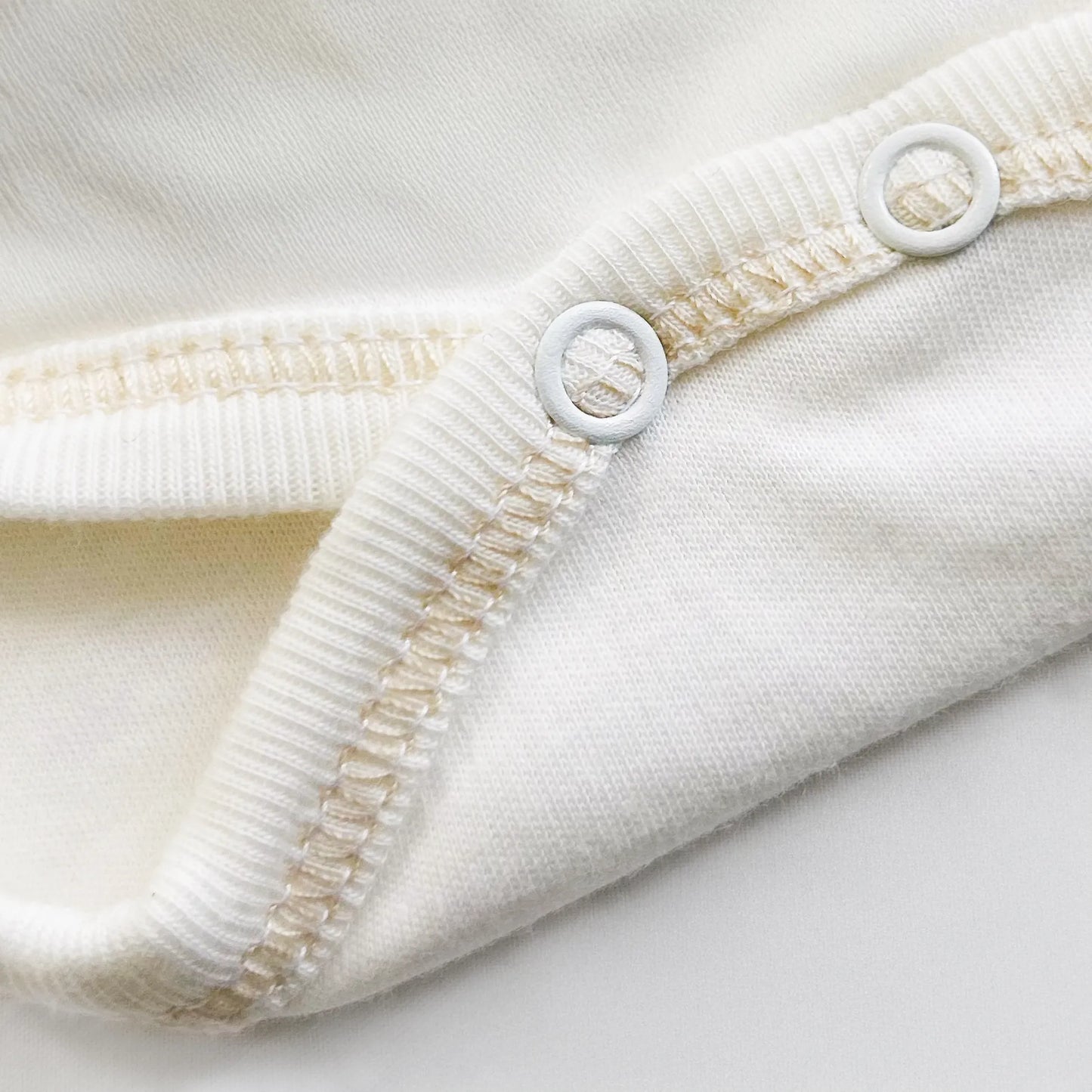 Detalle de body cruzado con leotardo perchado con motivo de conejos de punto y lazito beige