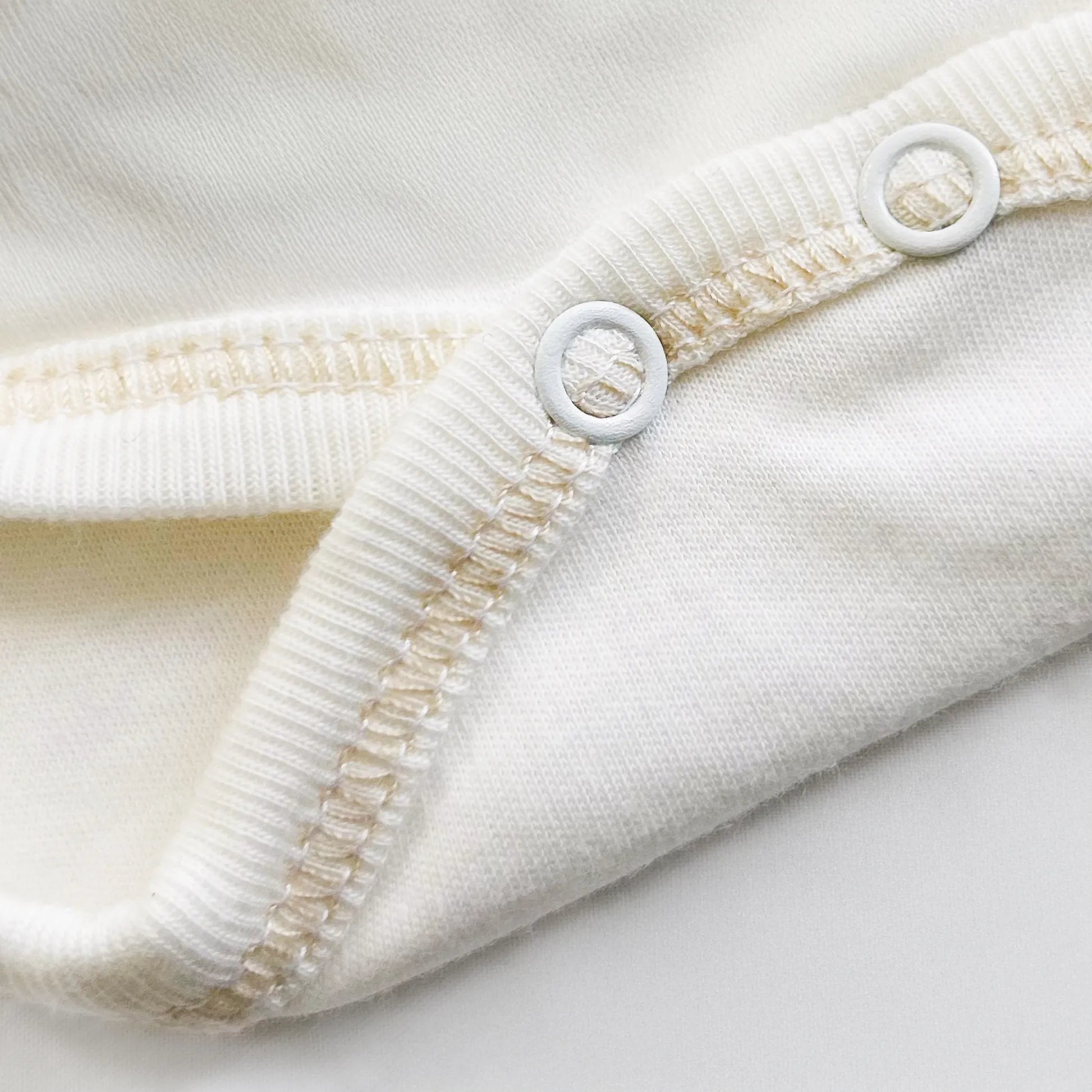 Detalle de body cruzado con leotardo perchado con motivo de conejos de punto y lazito beige