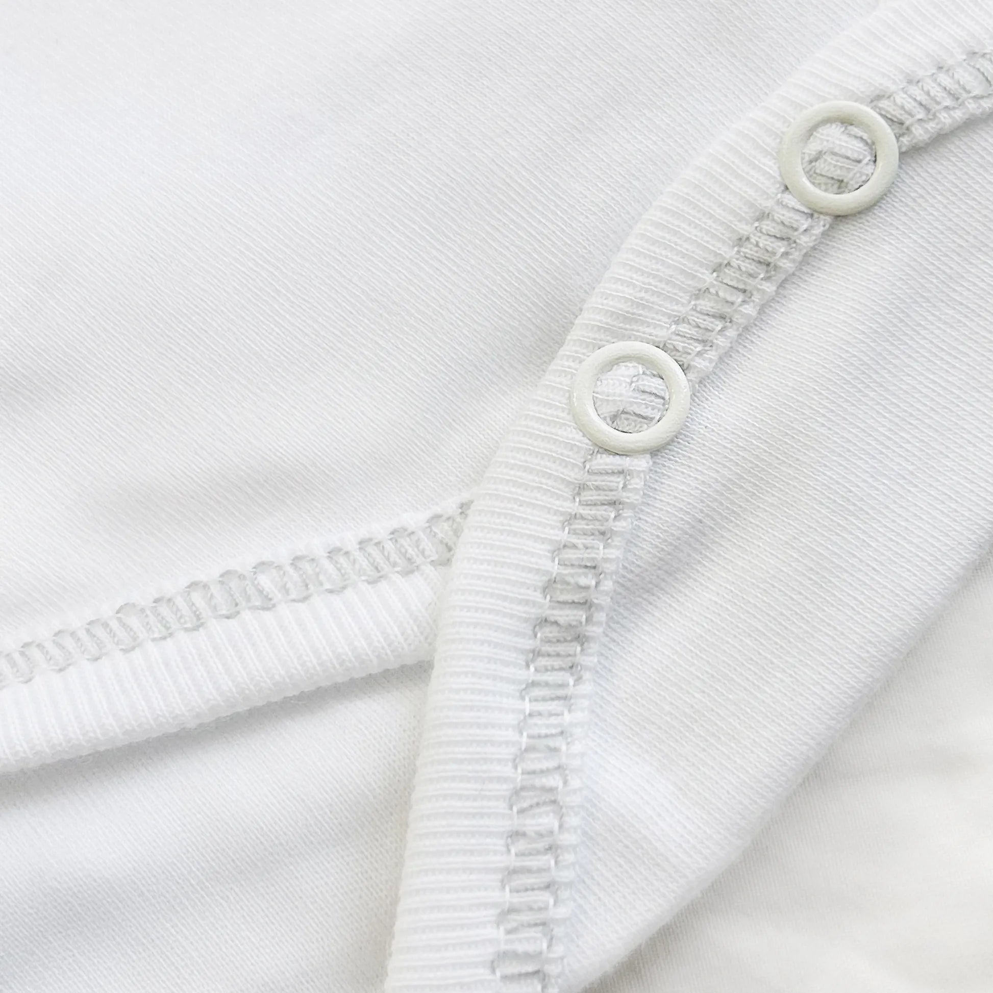 Detalle de body cruzado con leotardo perchado con motivo de conejos de punto y lazito gris