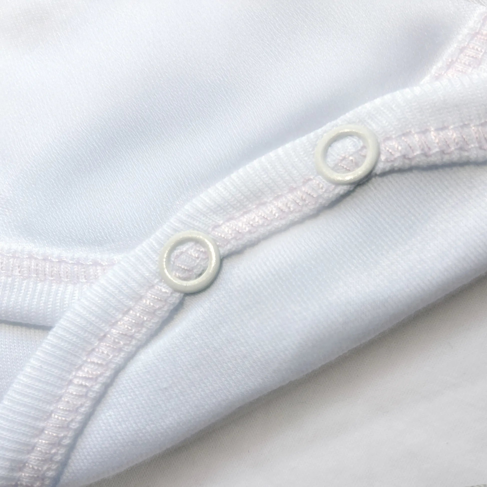 Detalle de body cruzado con leotardo perchado con motivo de conejos de punto y lazito rosa