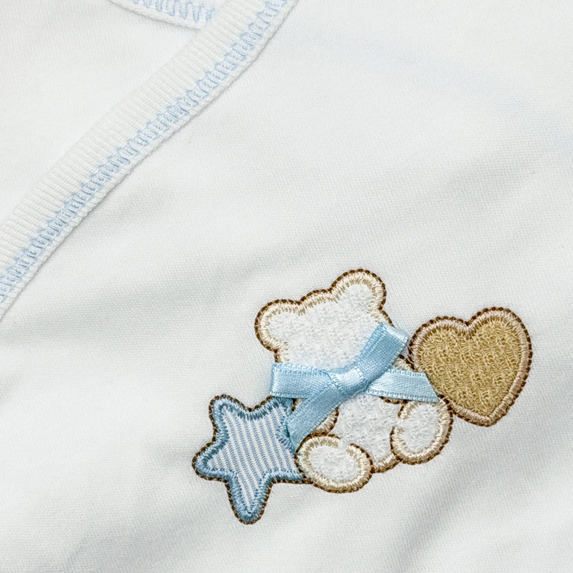 Detalle de body cruzado con polaina con motivo de osito entre estrella y corazón azul