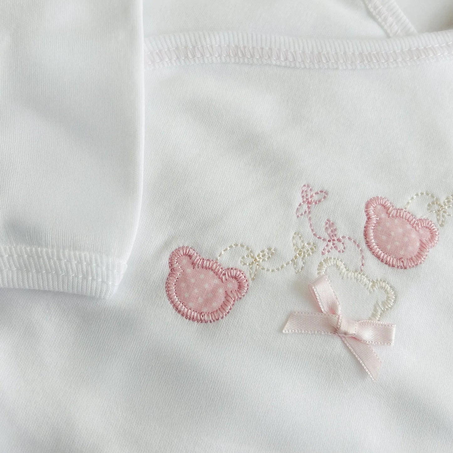 Detalle de body cruzado con leotardo con motivo de ositos con lunares rosa