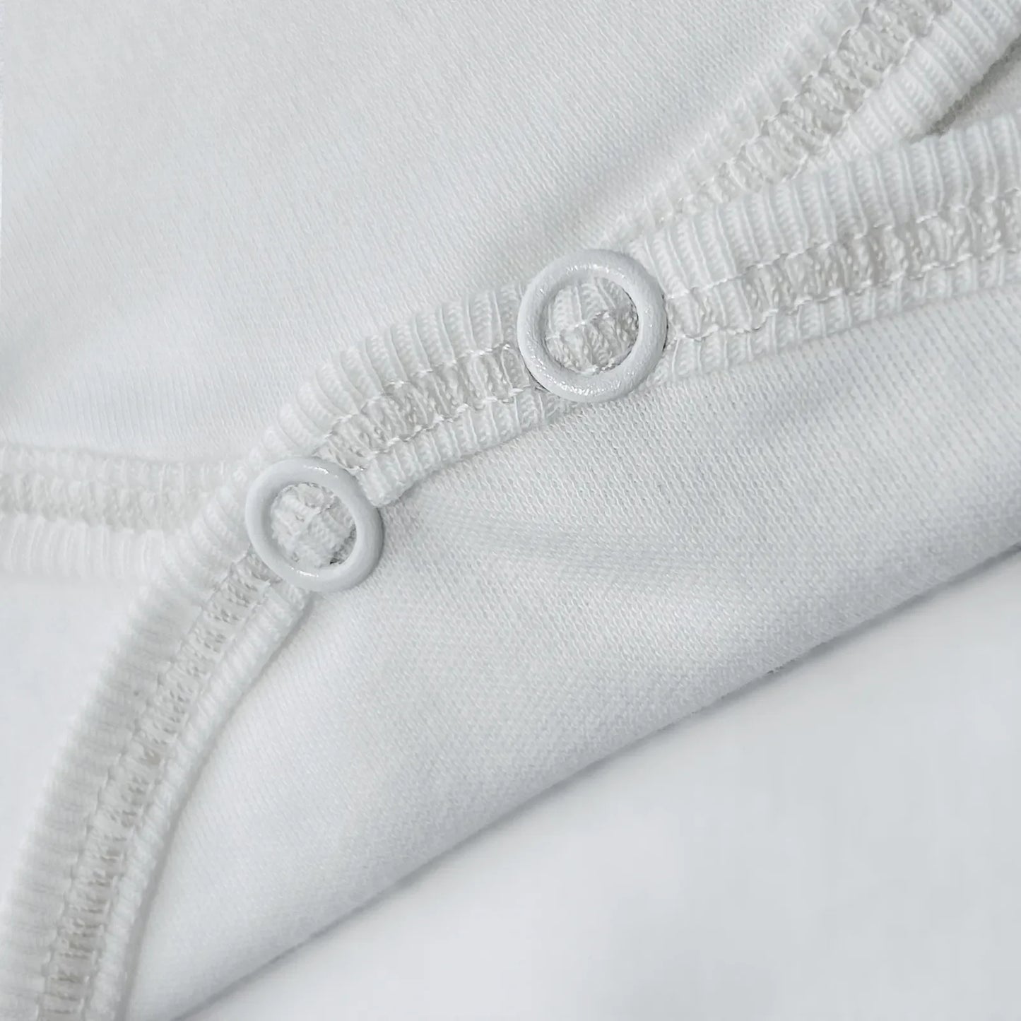 Detalle de body cruzado con pantalones com pies con bordado de lunares blanco