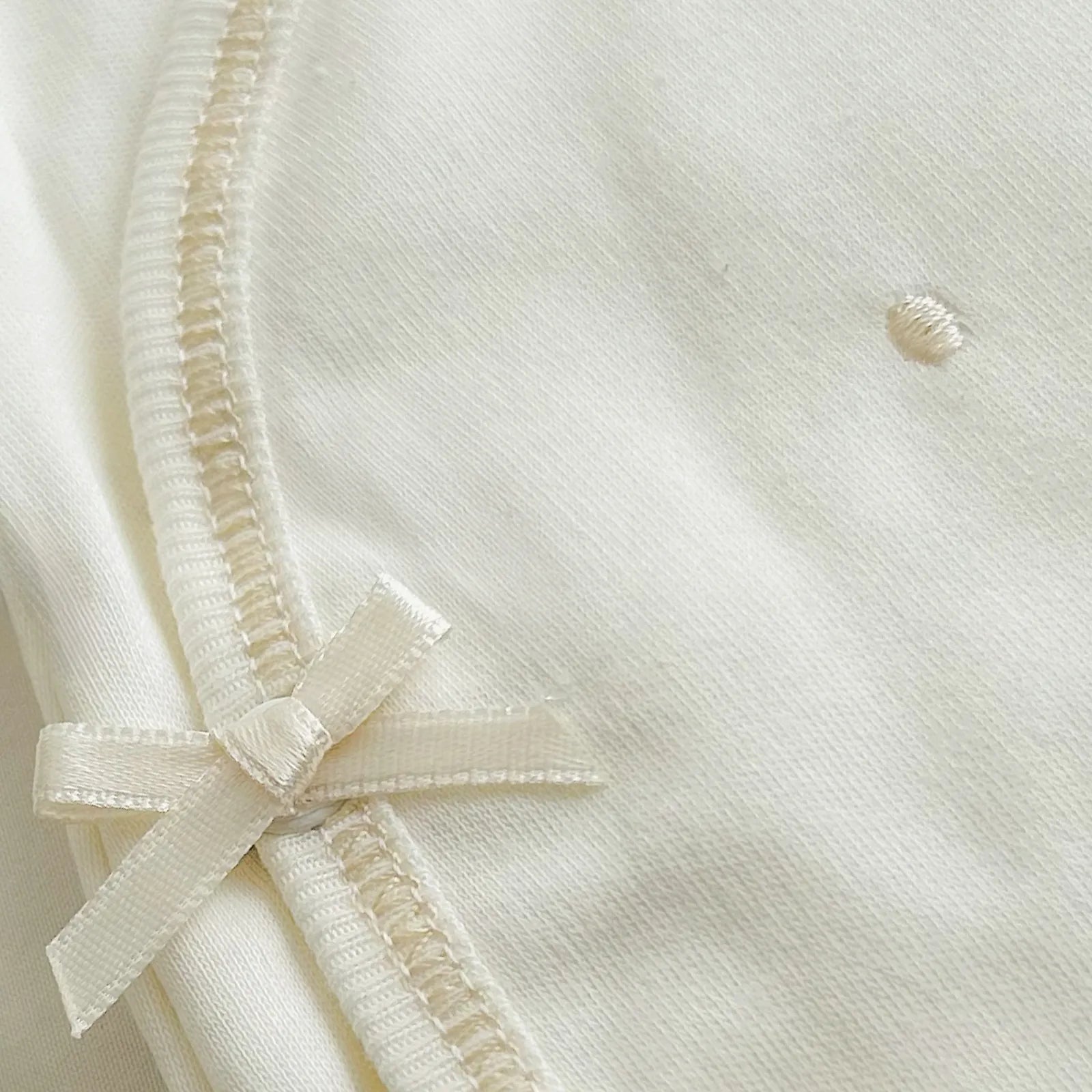 Detalle de body cruzado con pantalones com pies perla con bordado de lunares