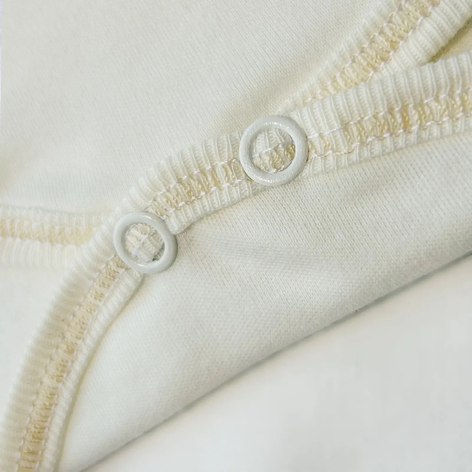 Detalle de body cruzado con pantalones com pies perla con bordado de lunares