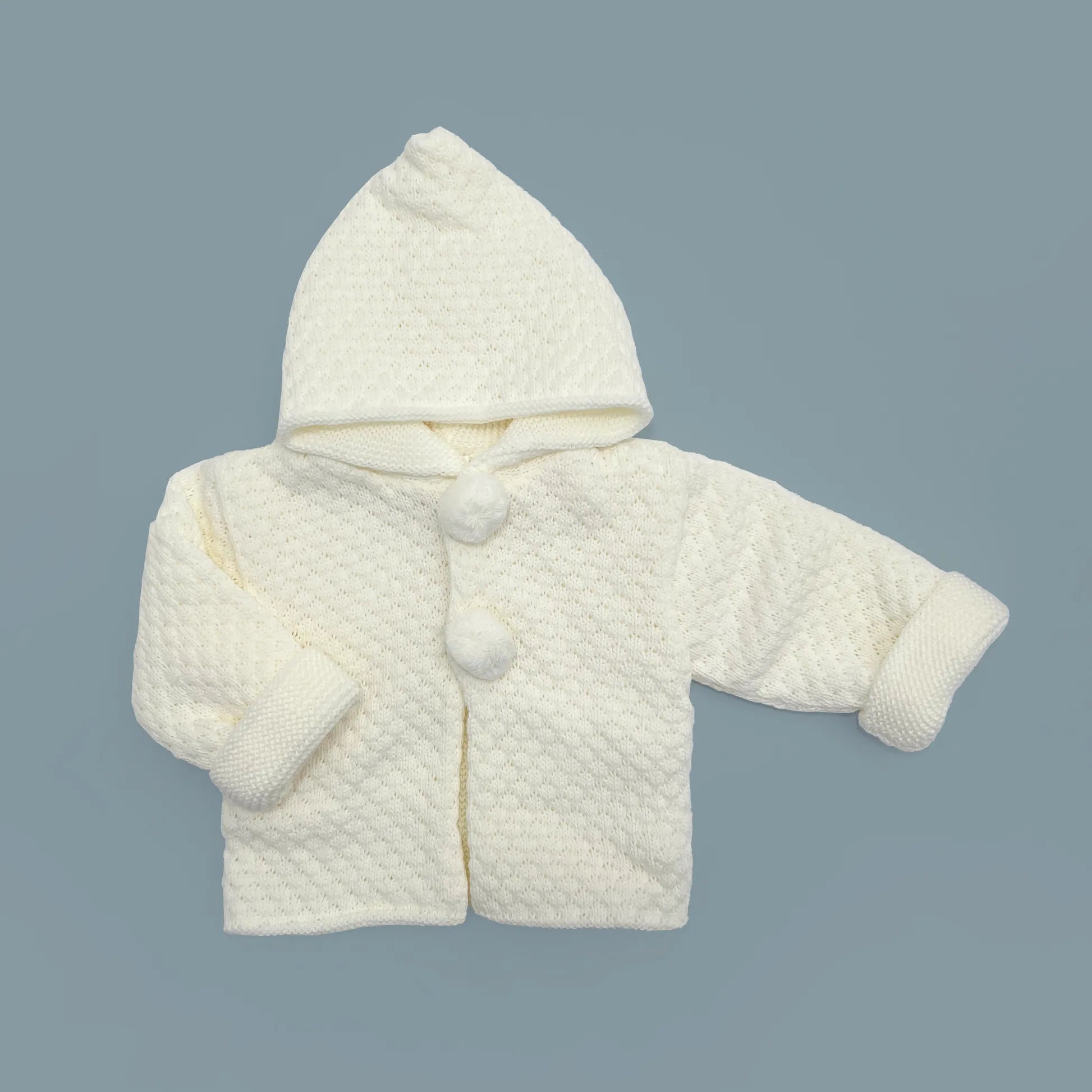 Chaqueta de punto con capucha y pompones en la zona de los botones perla