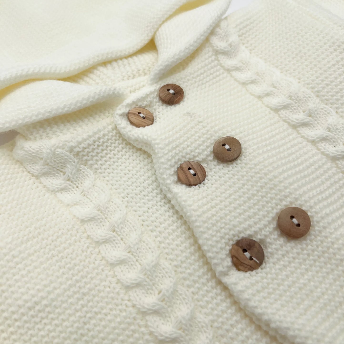 Detalles de chaqueta de punto con capucha y detalles trenzados en la parte delantera perla