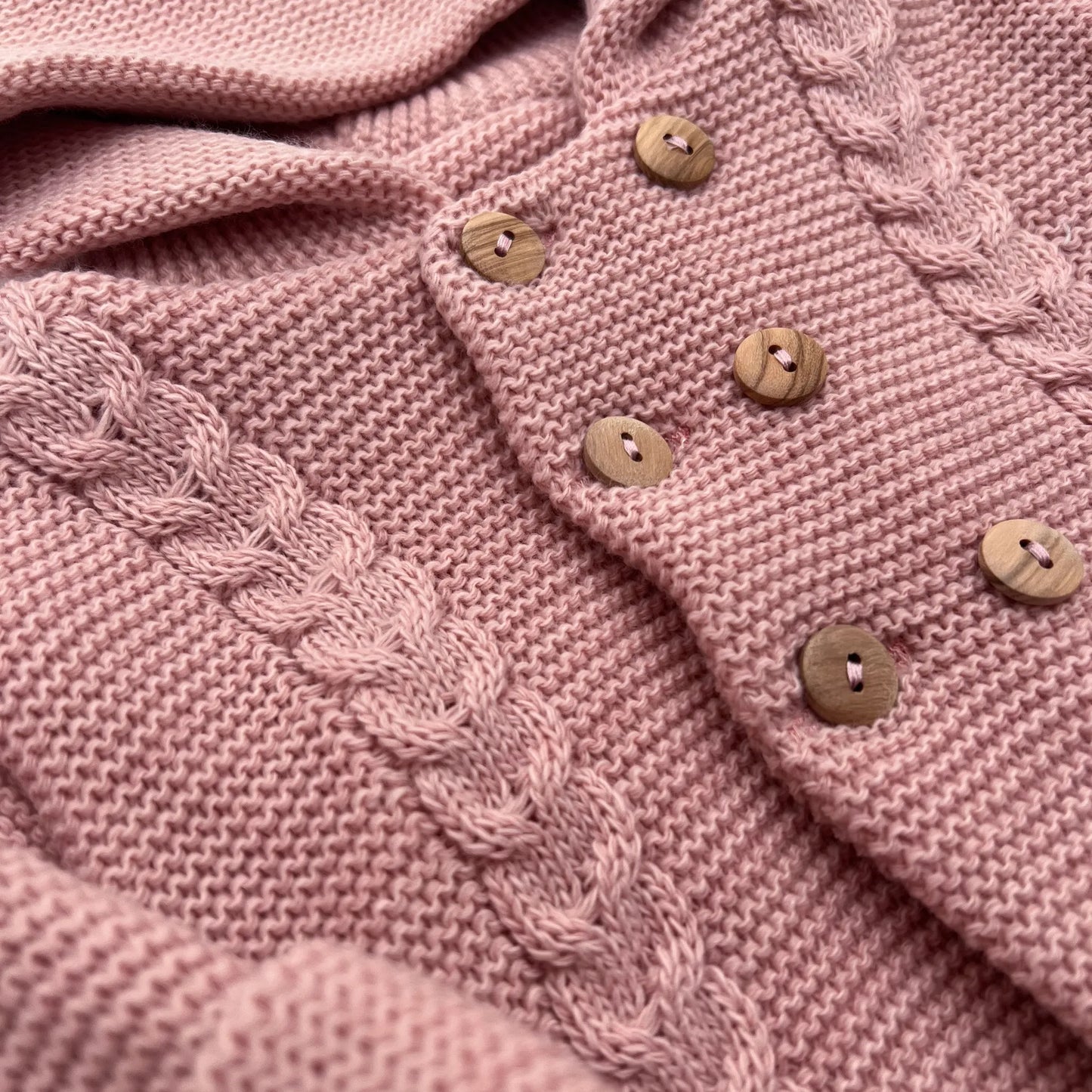 Detalles de chaqueta de punto con capucha y detalles trenzados en la parte delantera rosa