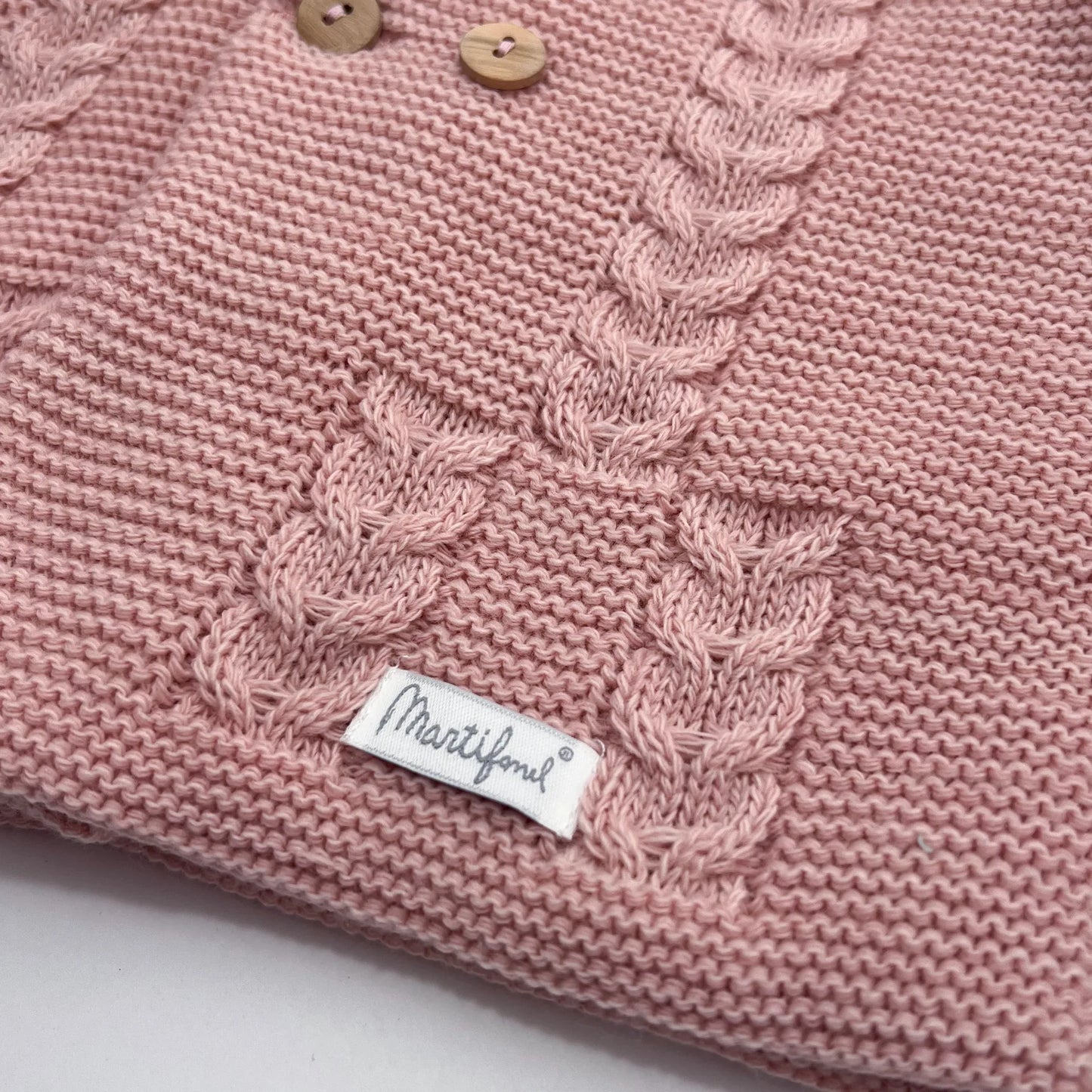 Detalles de chaqueta de punto con capucha y detalles trenzados en la parte delantera rosa