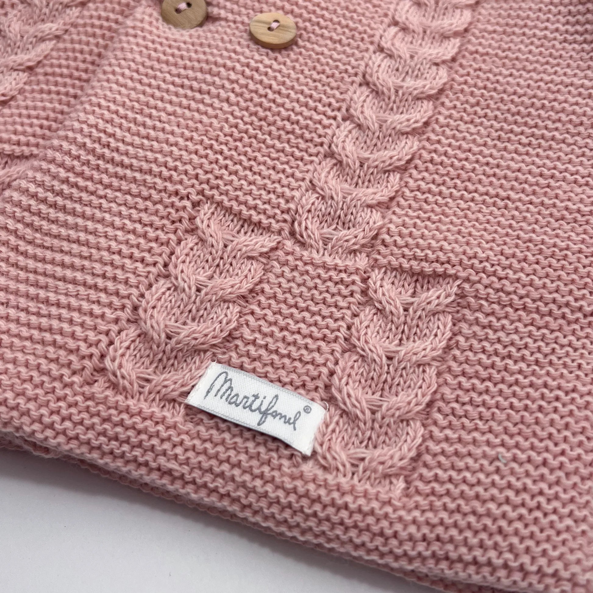 Detalles de chaqueta de punto con capucha y detalles trenzados en la parte delantera rosa