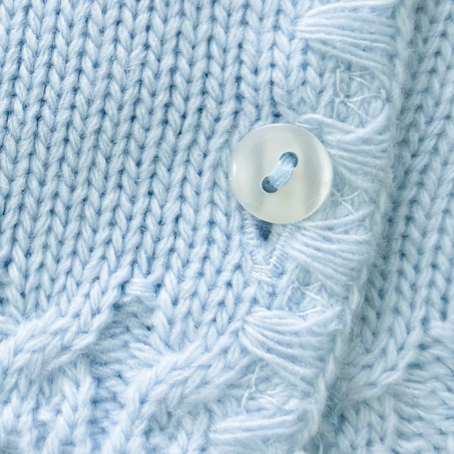 Detalle de chaqueta de punto con detalles trabajados en los bordes azul