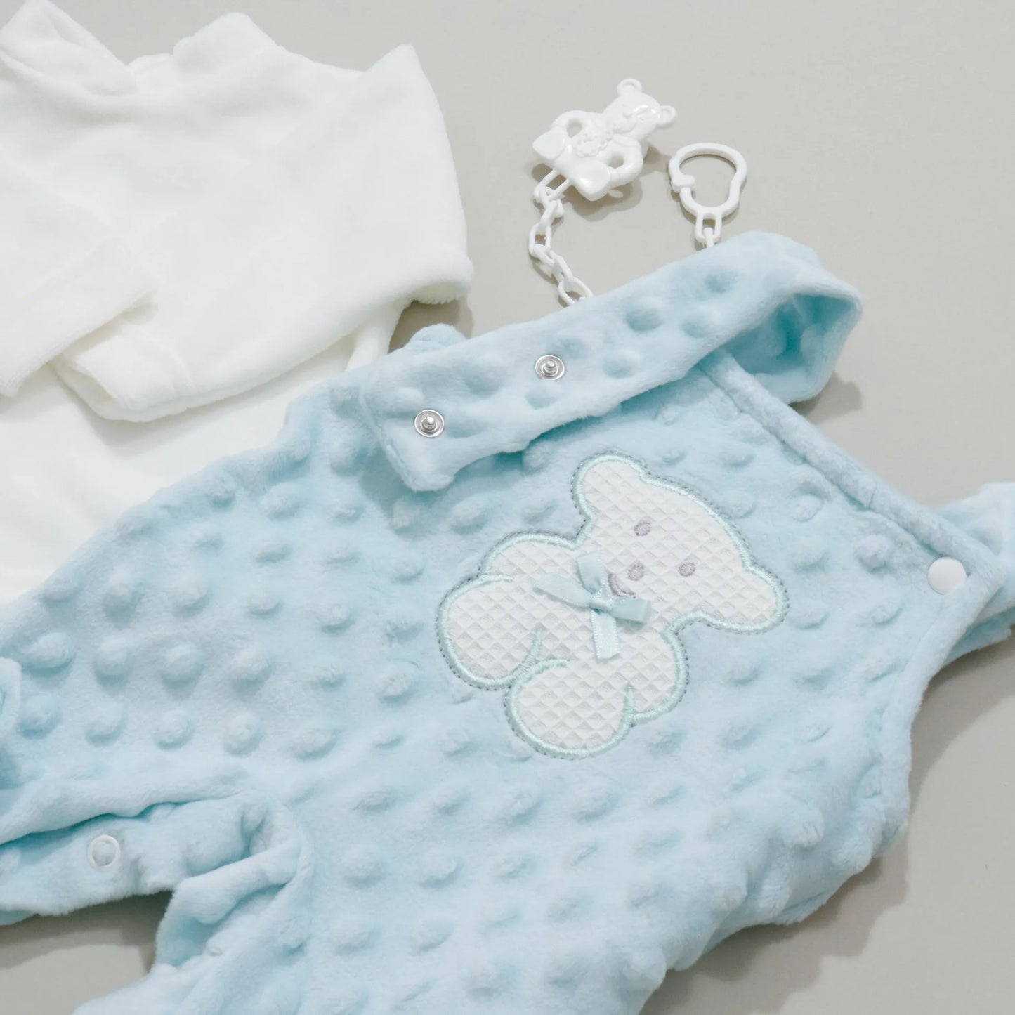 Detalle de conjunto de peto y camiseta perchada con motivo de osito waffle verde agua
