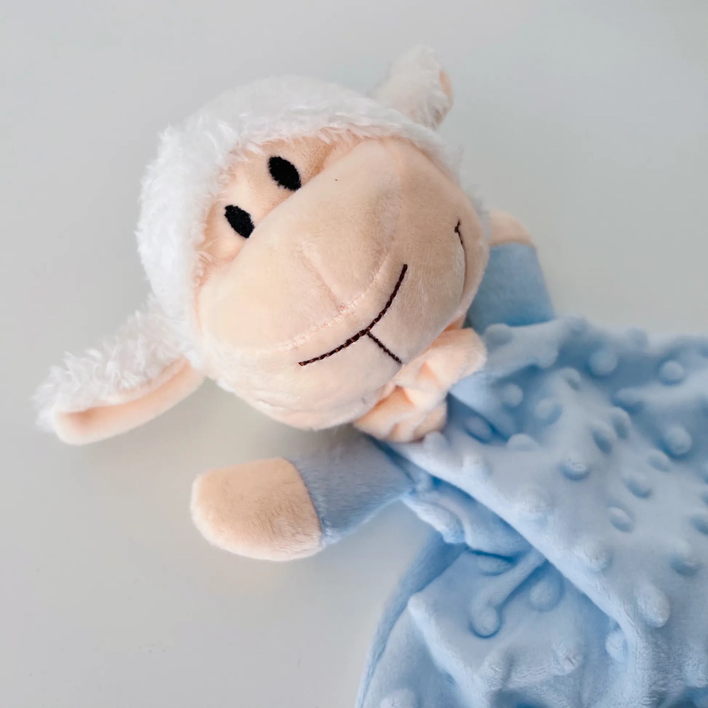 Doudou del conjunto de manta y doudou oveja con detalles en relieve azul