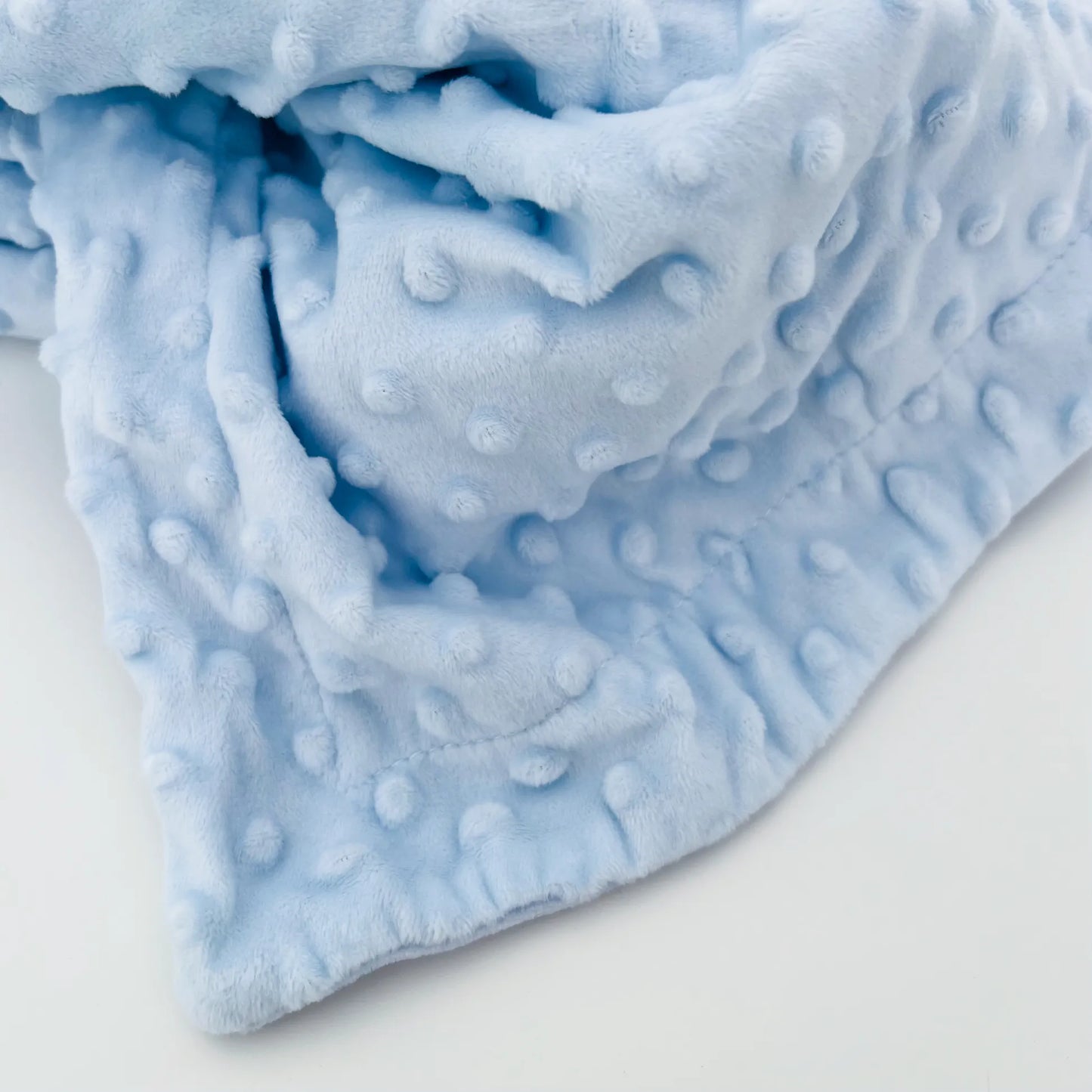 Detalle de conjunto de manta y doudou osito con detalles en relieve azul