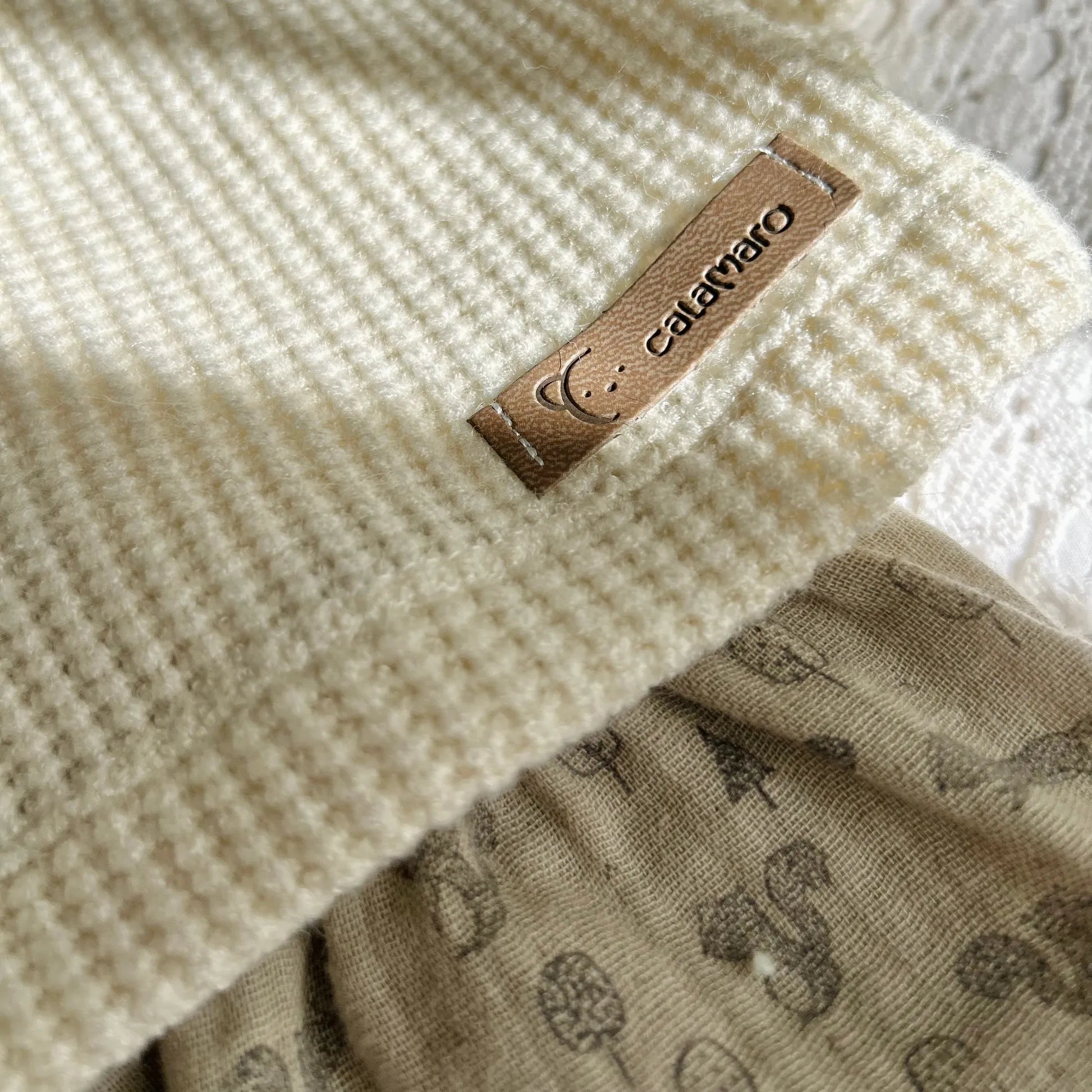 Detalle de conjunto de niña de camiseta color perla con volante en el cuello y cubrepañal gris