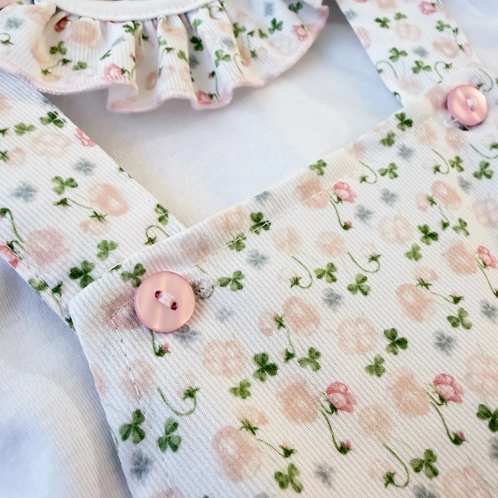 Detalle de conjunto de niña de peto y camiseta con estampado floral