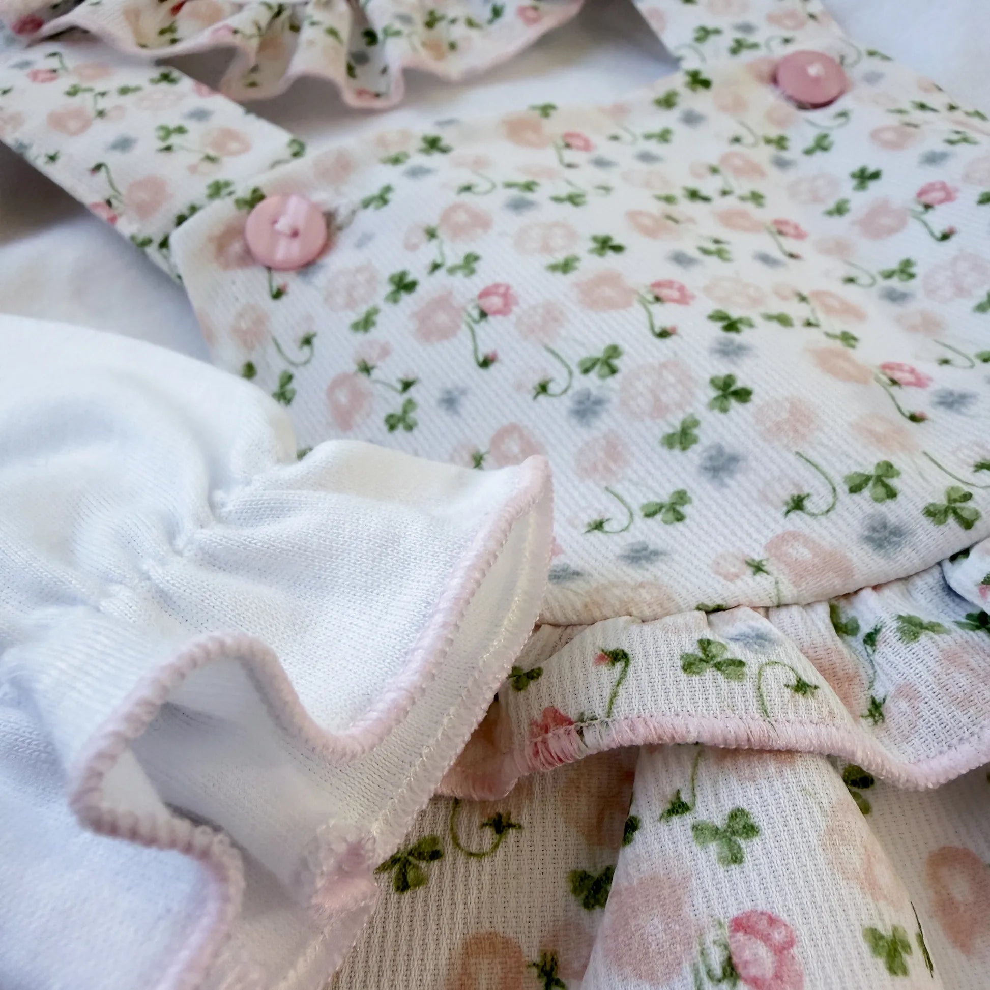 Detalle de conjunto de niña de peto y camiseta con estampado floral