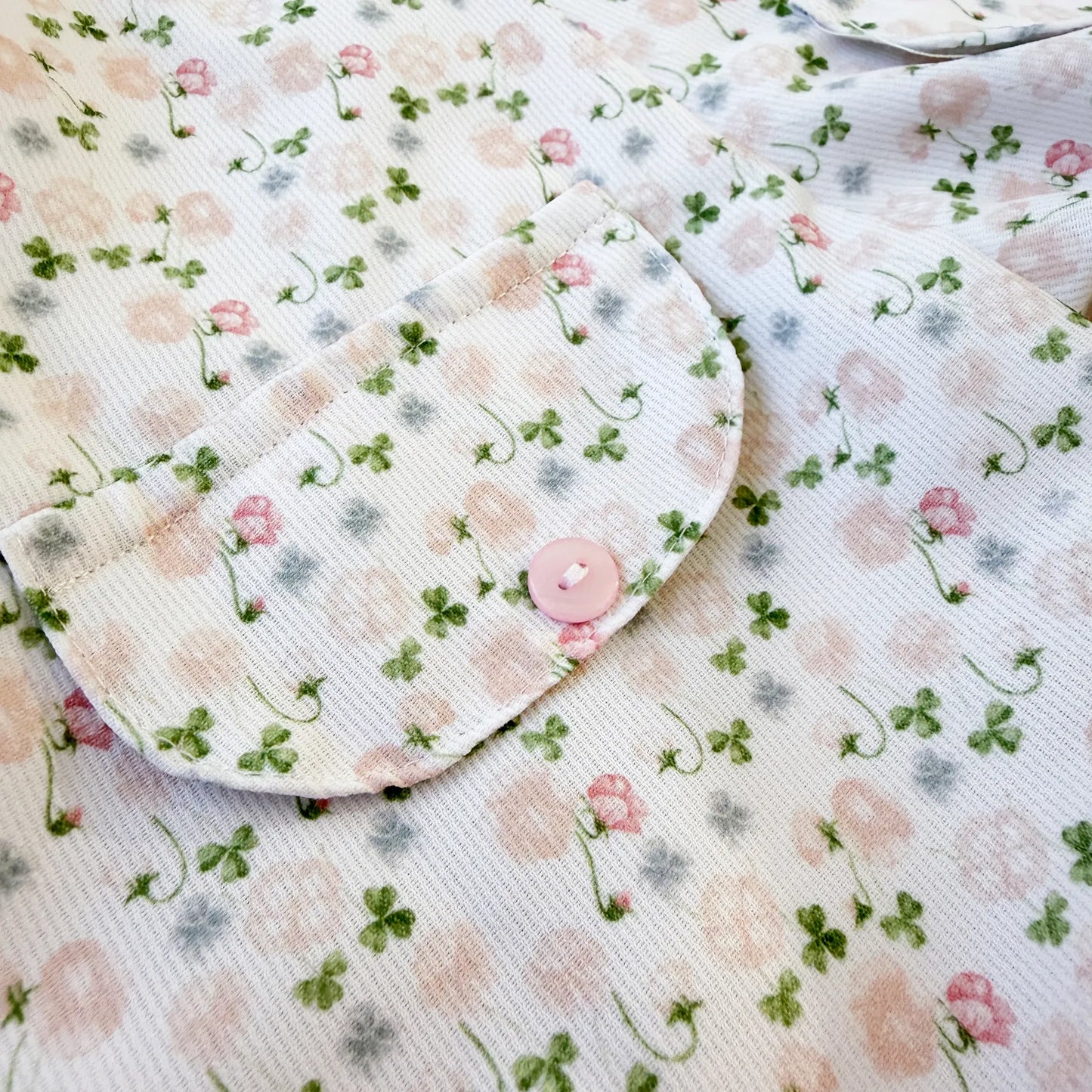 Detalle de conjunto de niña de peto y camiseta con estampado floral