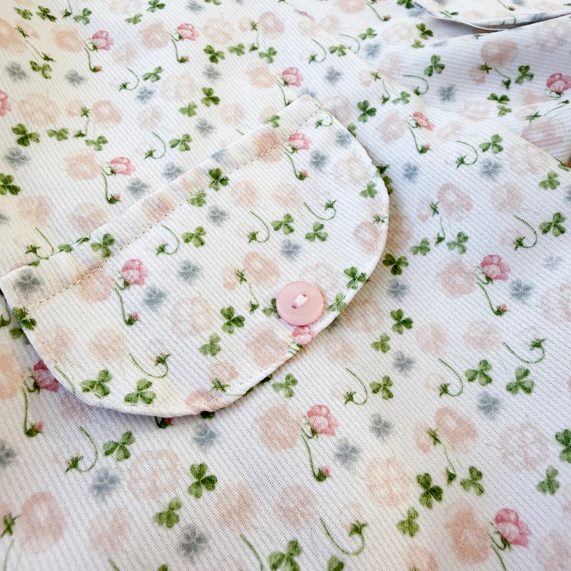 Detalle de conjunto de niña de peto y camiseta con estampado floral