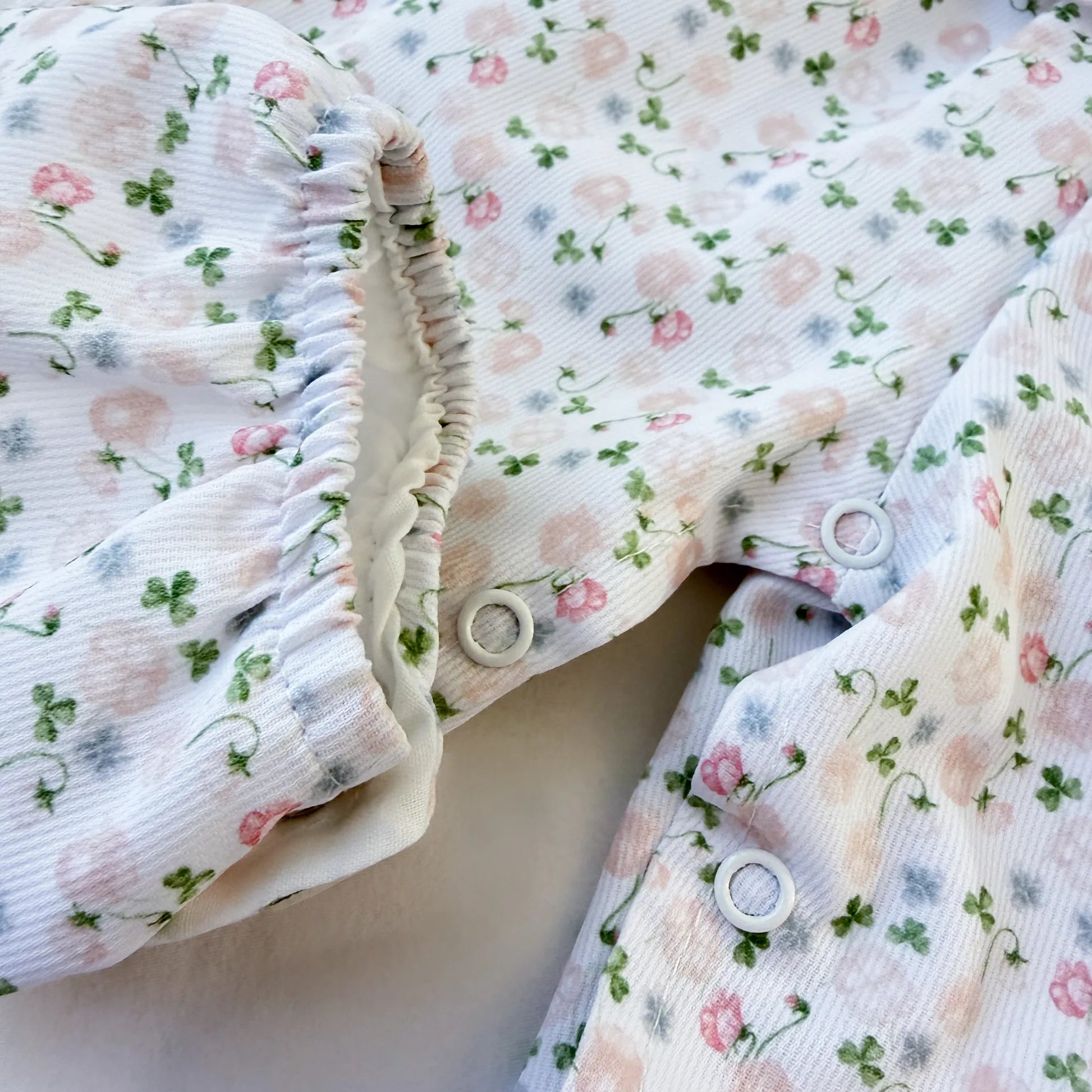 Detalle de conjunto de niña de peto y camiseta con estampado floral