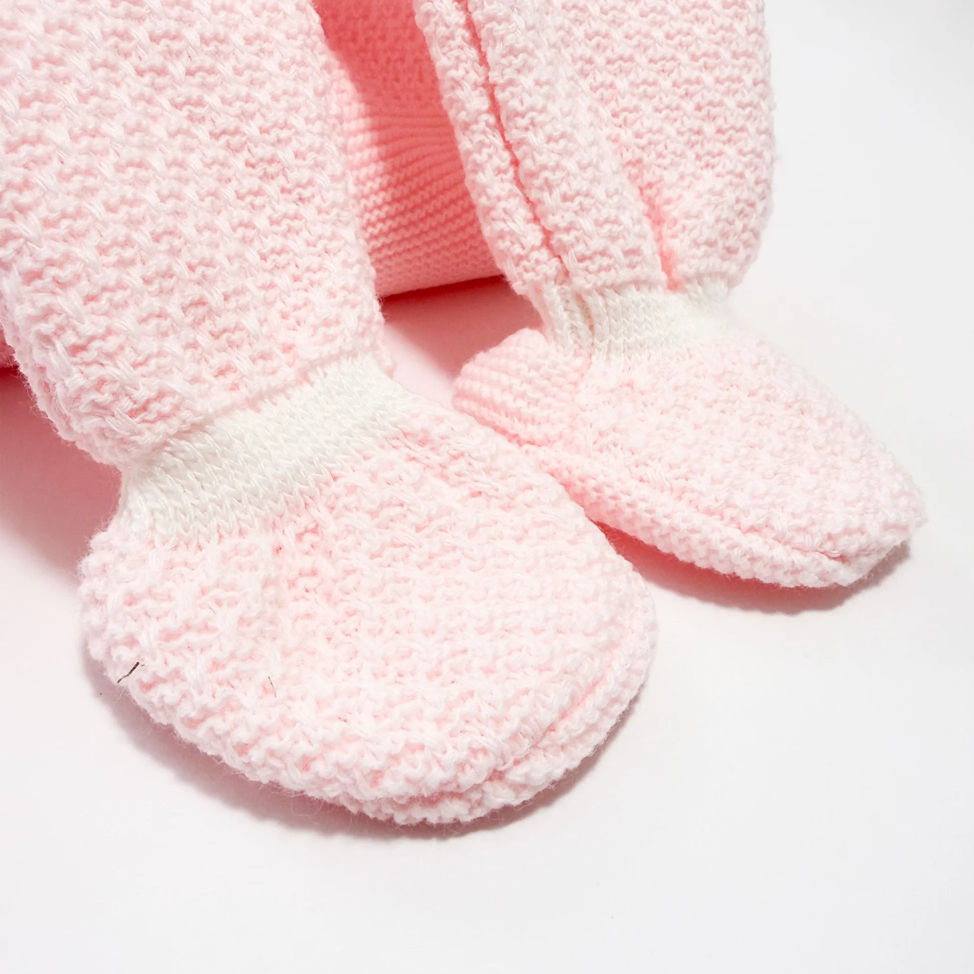 Detalle de conjunto de ni�a de peto con lazo, camiseta y gorro con pomp�n en tricot rosa