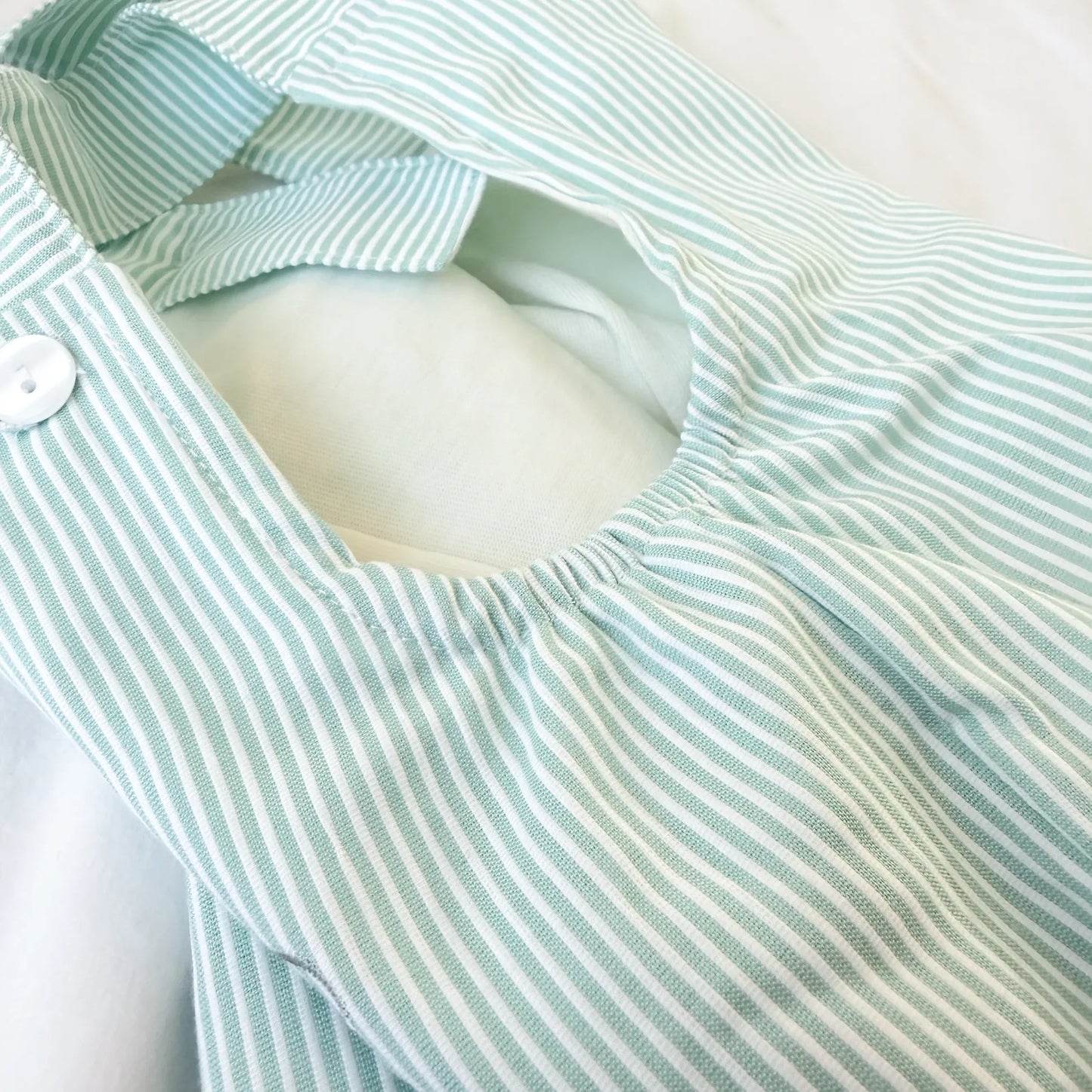Detalle de conjunto de niño de peto a rayas con motivo bordado verde