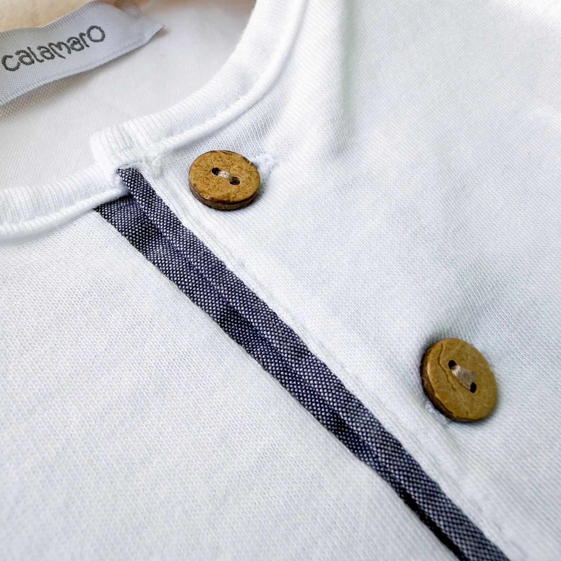Detalle de conjunto de niño de camiseta con botones y pantalón corto de tela marino